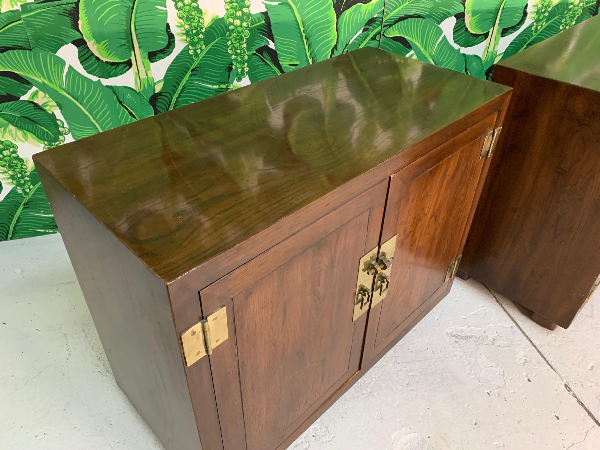 Pair of Henredon cabinets feature heavy brass hardware and double doors revealing large storage spaces. One cabinet with inner drawer and shelf, the other with single shelf. Very good condition with very minor imperfections consistent with age.