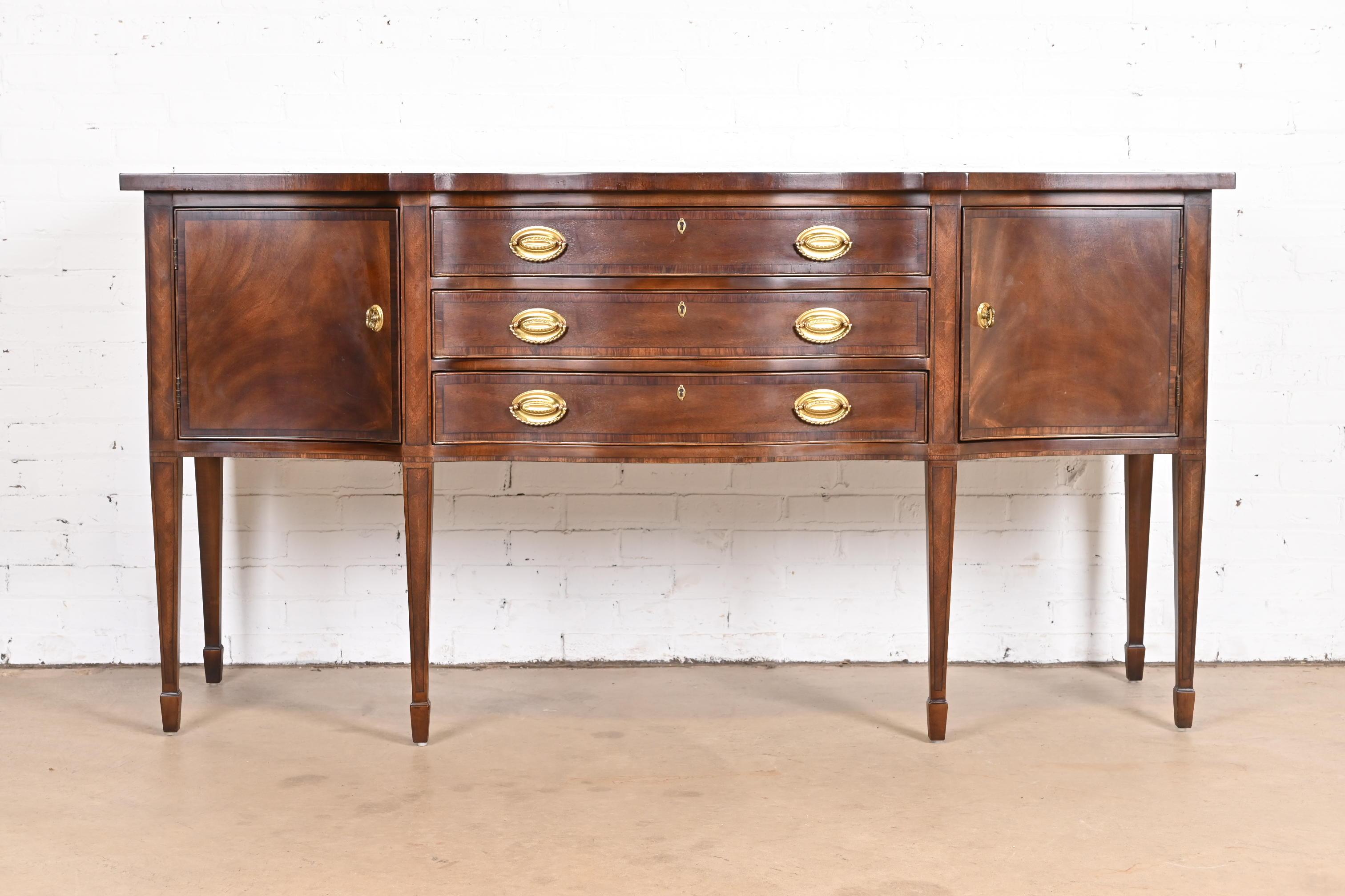 A gorgeous Federal or Hepplewhite style bow front sideboard buffet or credenza

By Henredon

USA, Circa 1980s

Beautiful banded flame mahogany, with original brass hardware.

Measures: 72