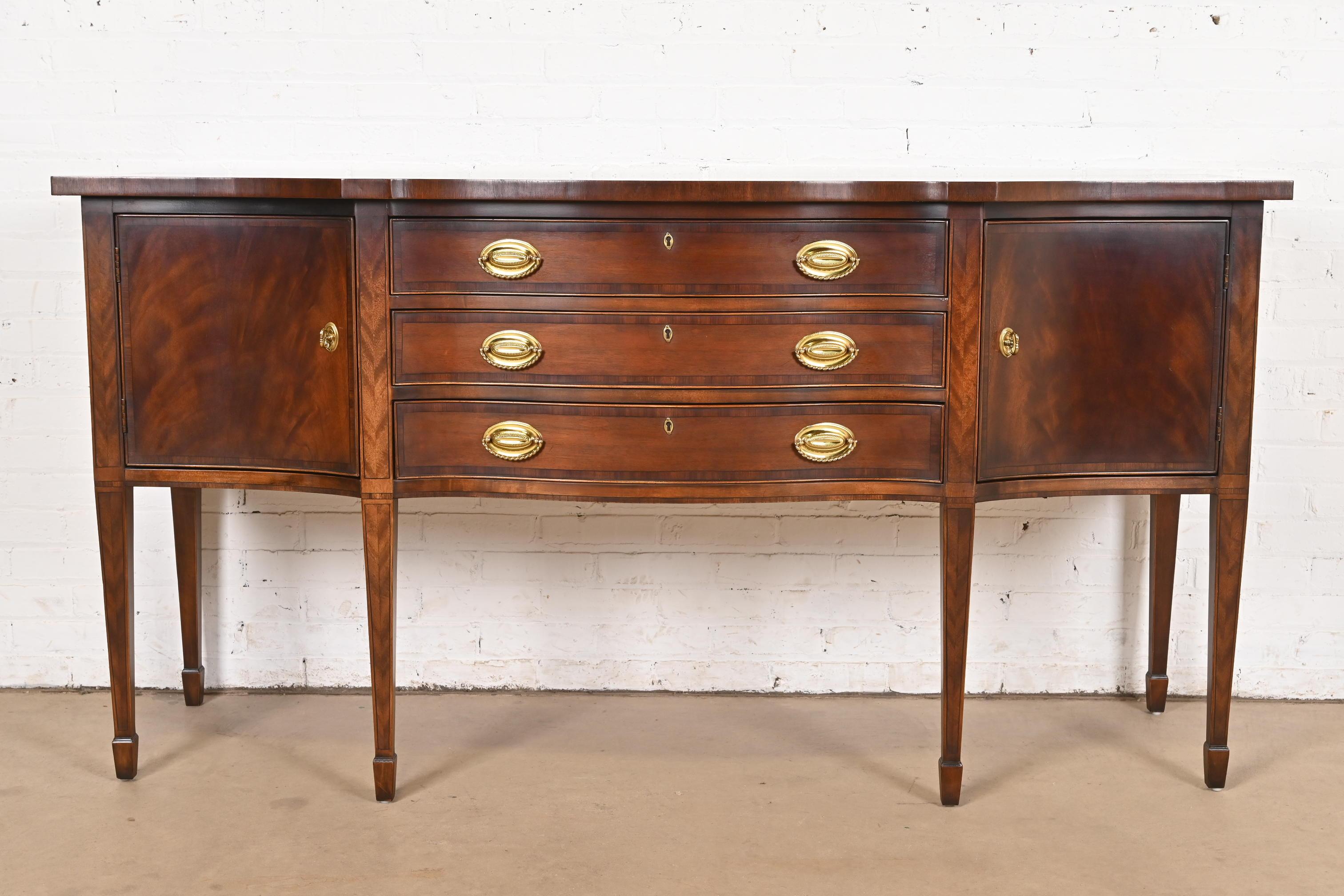 A gorgeous Federal or Hepplewhite style bow front sideboard buffet or credenza

By Henredon

USA, Circa 1980s

Beautiful banded flame mahogany, with original brass hardware.

Measures: 72