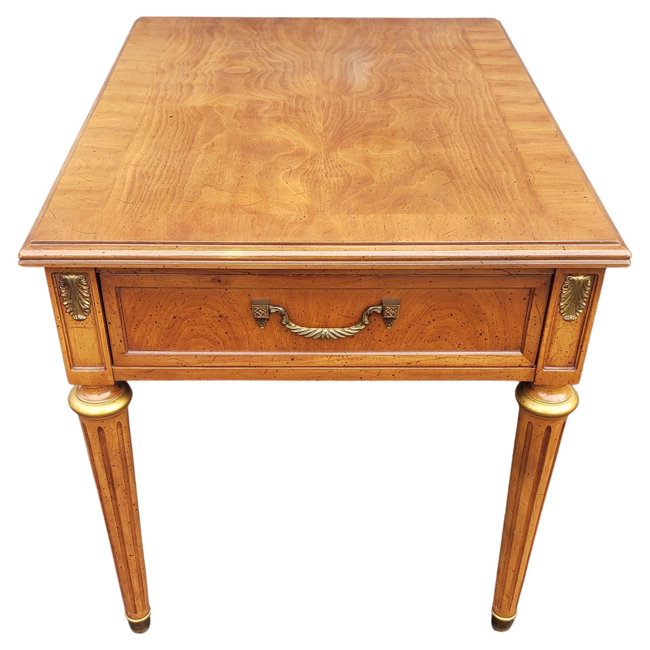Offered to you is this Henredon Fine Furniture burl walnut banded top side table. One dovetailed drawer with drop down pull. Brass medallions, cannelured legs, brass capped legs and gold accents. 
Absolutely beautiful and in very good condition.