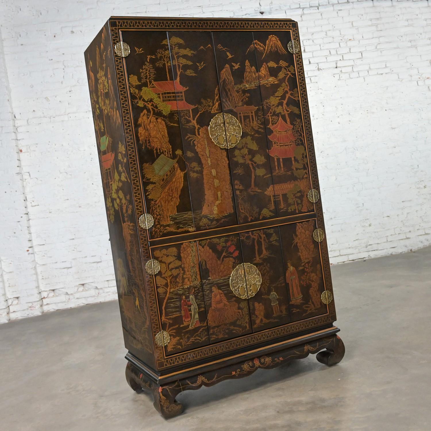 Incredible Late 20th Century Chinoiserie entertainment storage cabinet or armoire with painted scenic designs, Ming style feet, brass hardware, and a lighted center section by Henredon from their Folio 10 Collection. Beautiful condition, keeping in