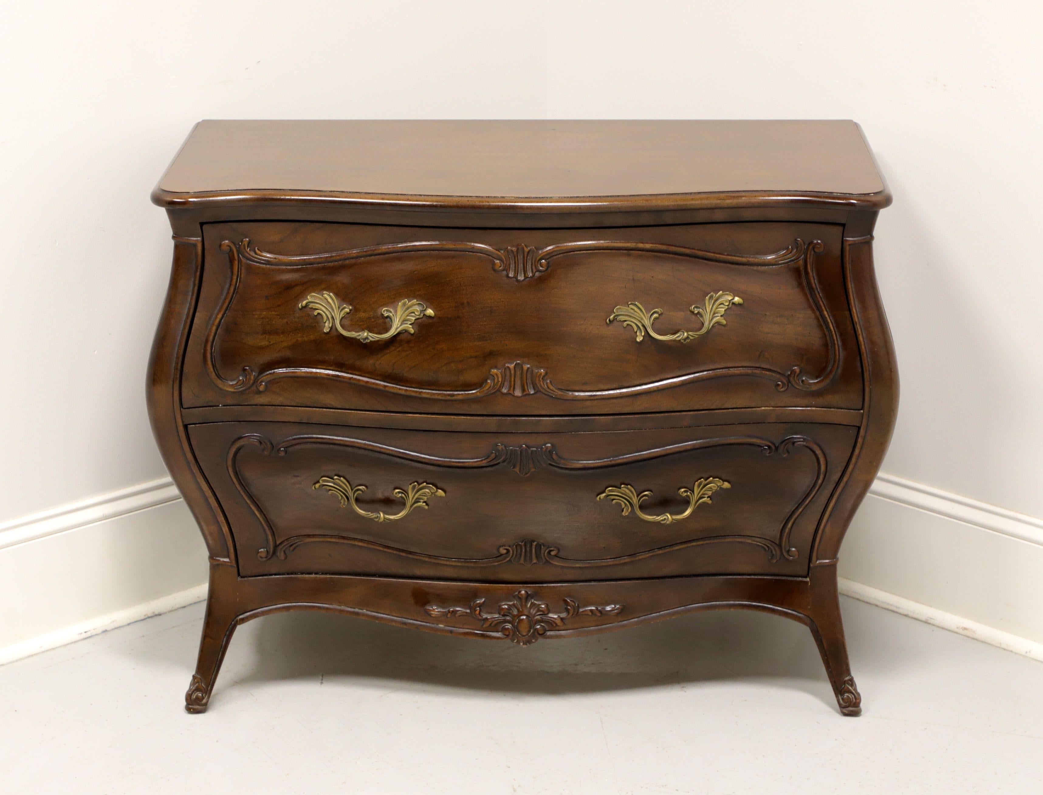 A French Country style low bombe chest by Henredon, from their Folio 10 Collection. Walnut with decorative brass hardware, curved front, carved apron and flared legs. Features two drawers of dovetail construction. Made in the USA, in the late 20th