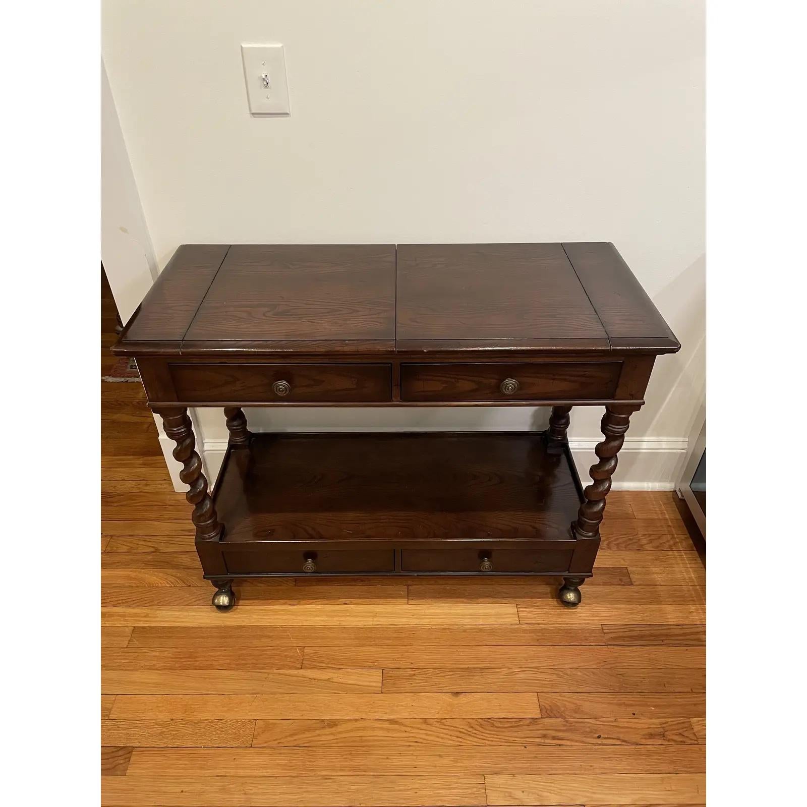 Vintage Henredon four centuries rolling buffet or server. Made of oak, featuring a flip top that opens over four barley twisted supports between two sets of drawers and large castors.

Measure: Width open - 56