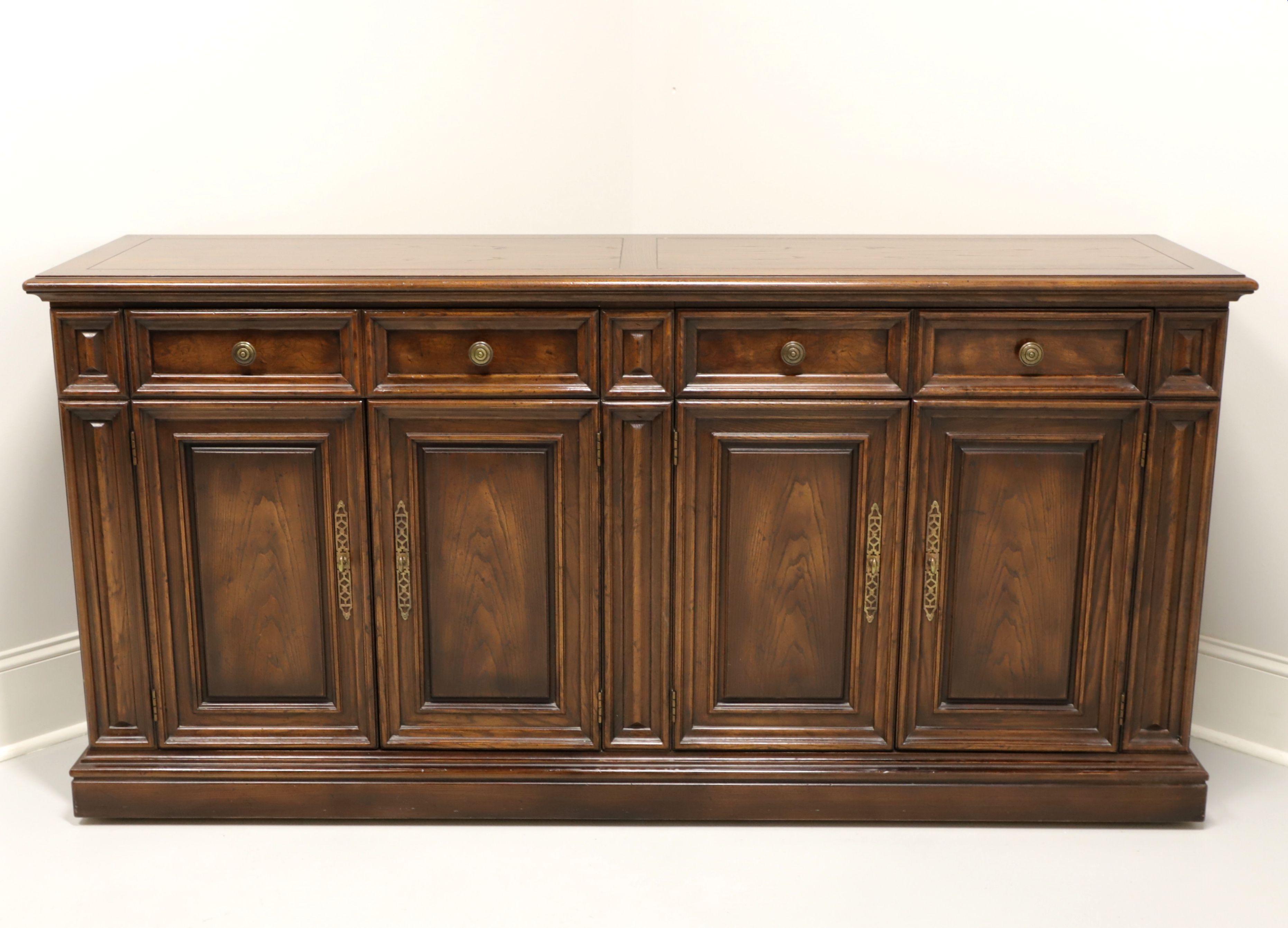 A Tudor style credenza by Henredon, from their Four Centuries Collection. Solid oak with banded top, brass hardware, raised panel doors, drawer fronts, center & sides and on wheels for easier movement. Features two drawers of dovetail construction