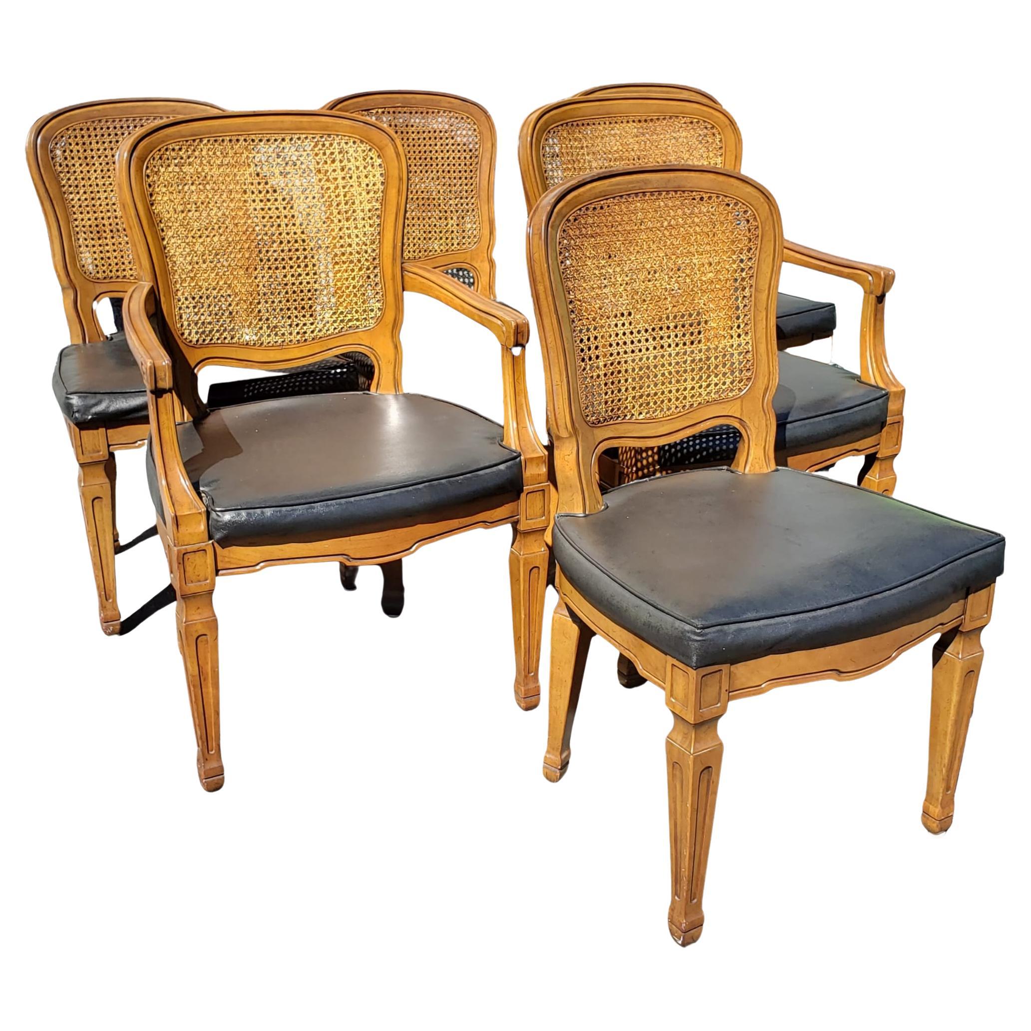 Rare Vintage French cane back dining chairs with leatherette seats by Henredon.
Faux leather seats in good condition as well as caning work. 
Side chairs measure 20.5