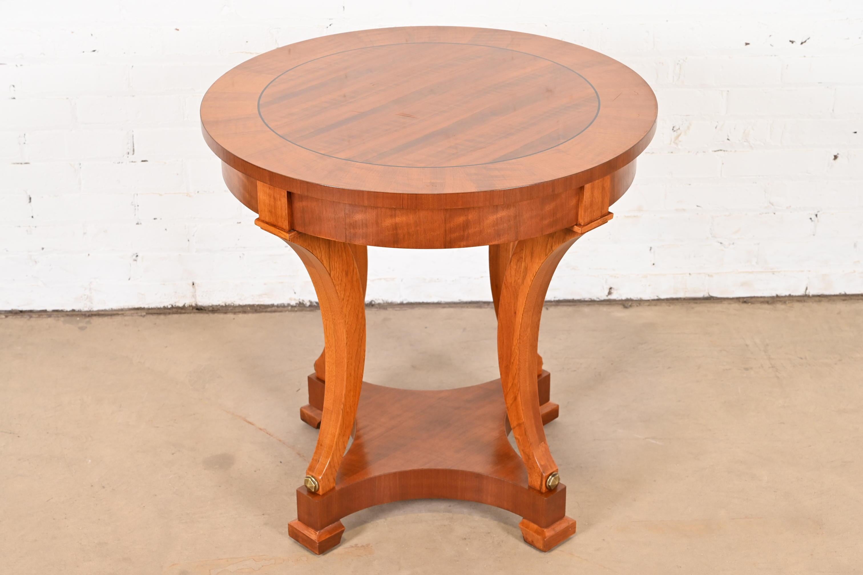 An exceptional French Empire, Regency, or Biedermeier style tea table or center table

By Henredon

USA, Circa Late 20th Century

Gorgeous carved mahogany, with ebony string inlay, and brass accents.

Measures: 28