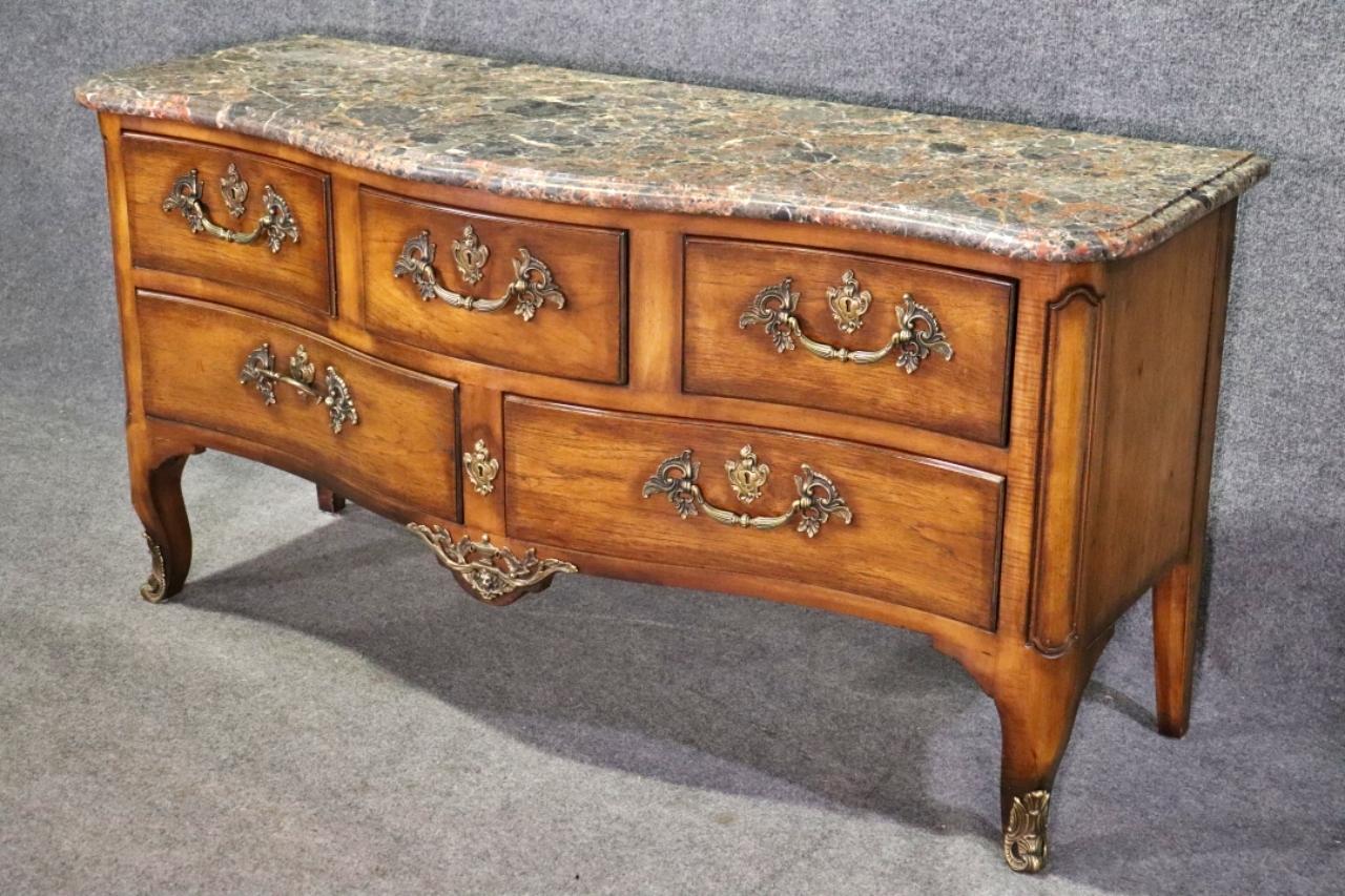 Wood. Marble top. 5 dovetail drawers. Brass hardware. Brass accents. 32 3/4