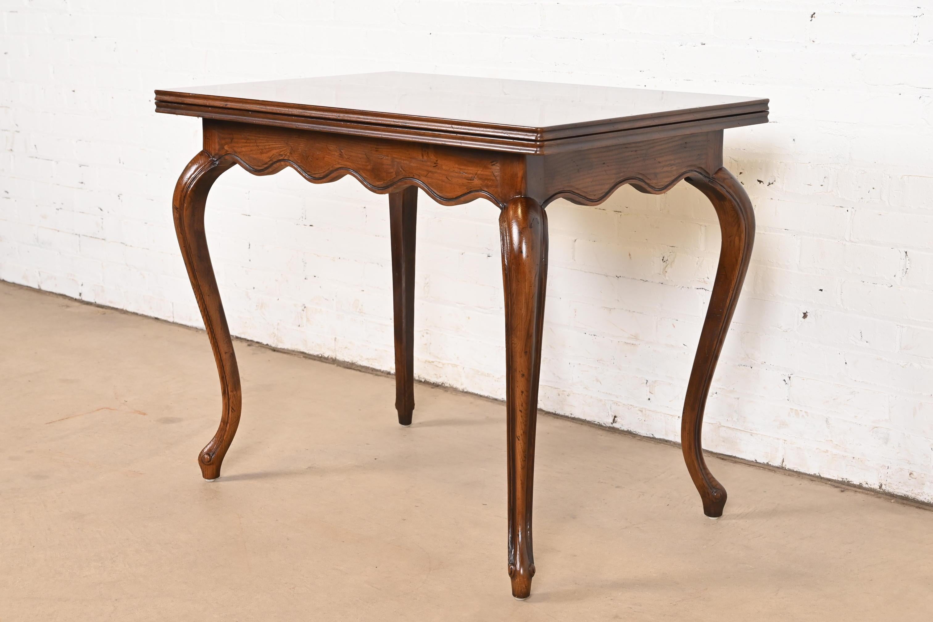 A gorgeous French Country or French Provincial Louis XV style flip top console game table or breakfast table

By Henredon

USA, Circa 1970s

Carved oak, with beautiful parquet top.

Measures: 36