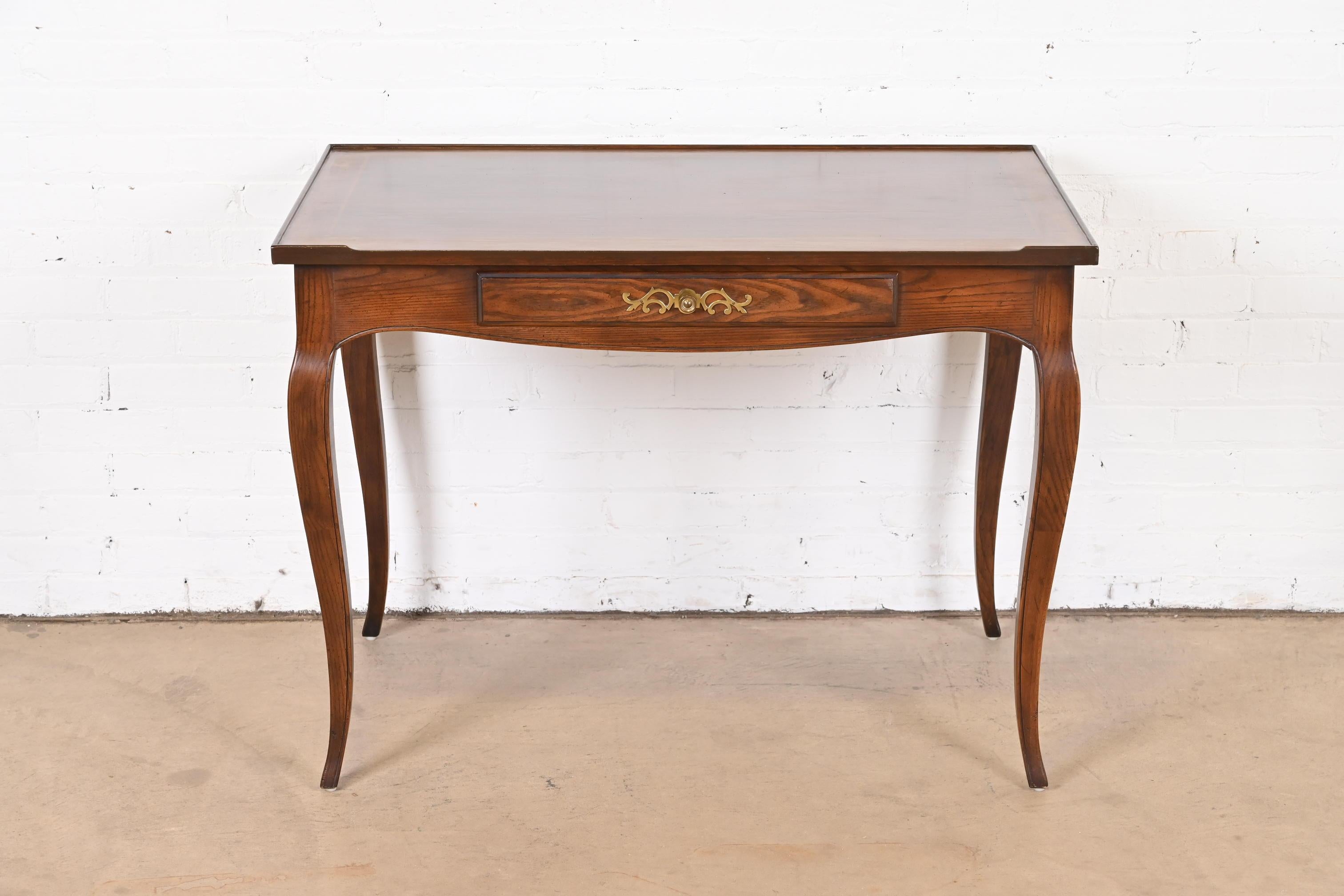 An exceptional French Provincial Louis XV style writing desk

By Henredon

USA, Circa 1960s

Carved oak, with original brass hardware.

Measures: 40