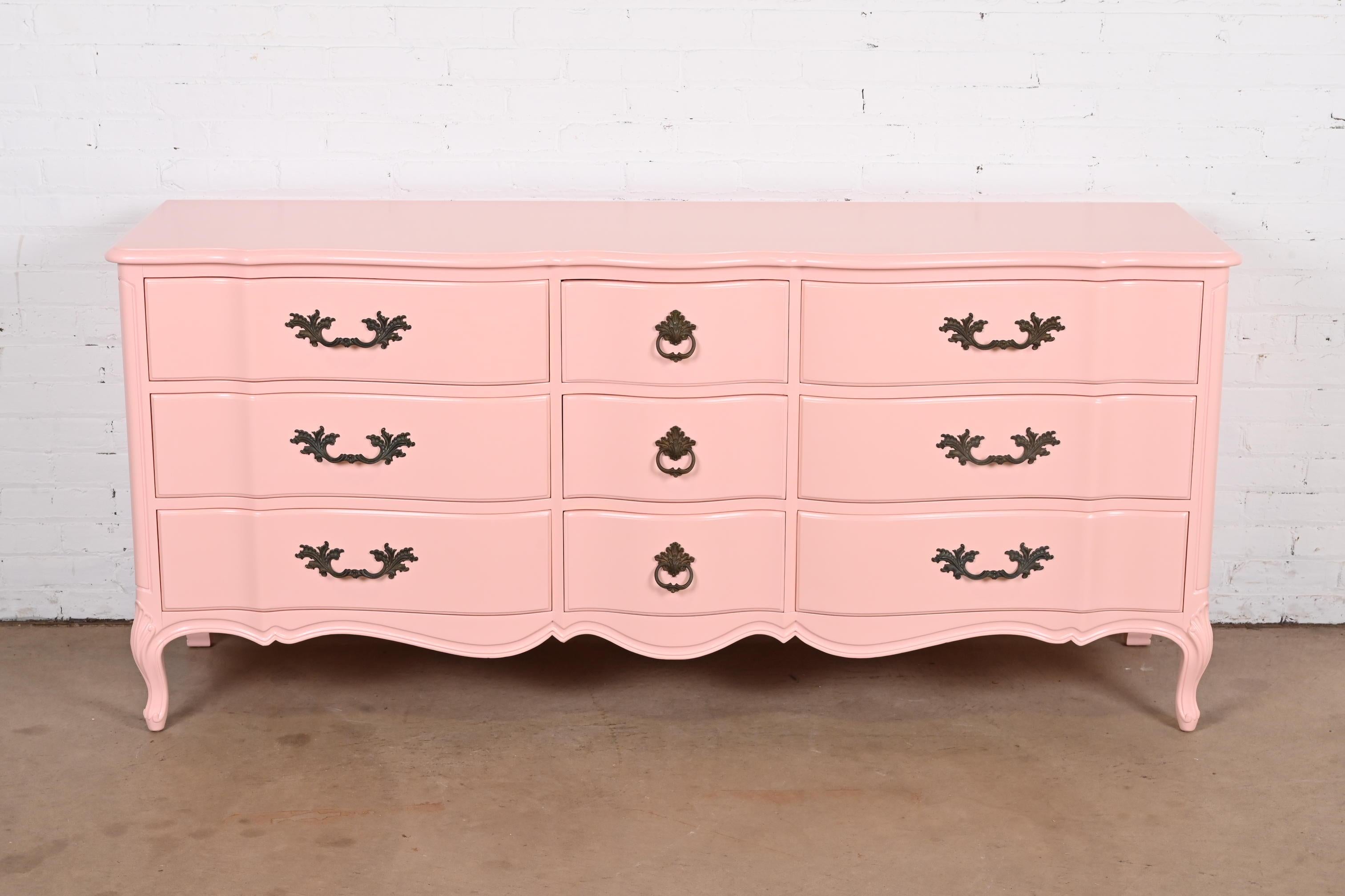 A gorgeous French Provincial Louis XV style nine-drawer triple dresser or credenza

By Henredon

USA, Circa 1960s

Pink lacquered solid cherry wood, with original brass hardware.

Measures: 72