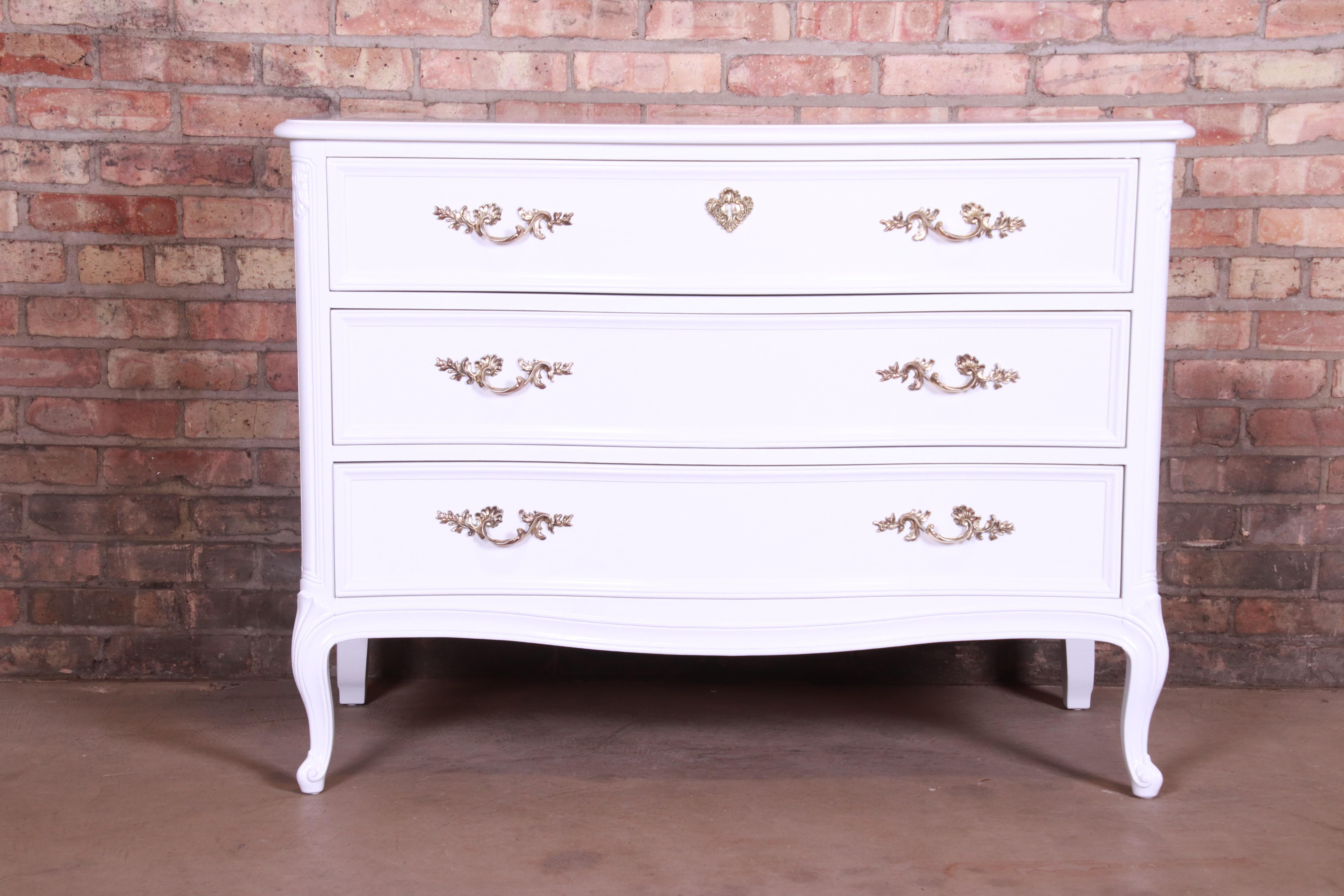 An exceptional French Provincial Louis XV style three-drawer dresser chest, commode, or server

By Henredon

USA, circa 1960s

White lacquered mahogany, with original brass hardware.

Measures: 42