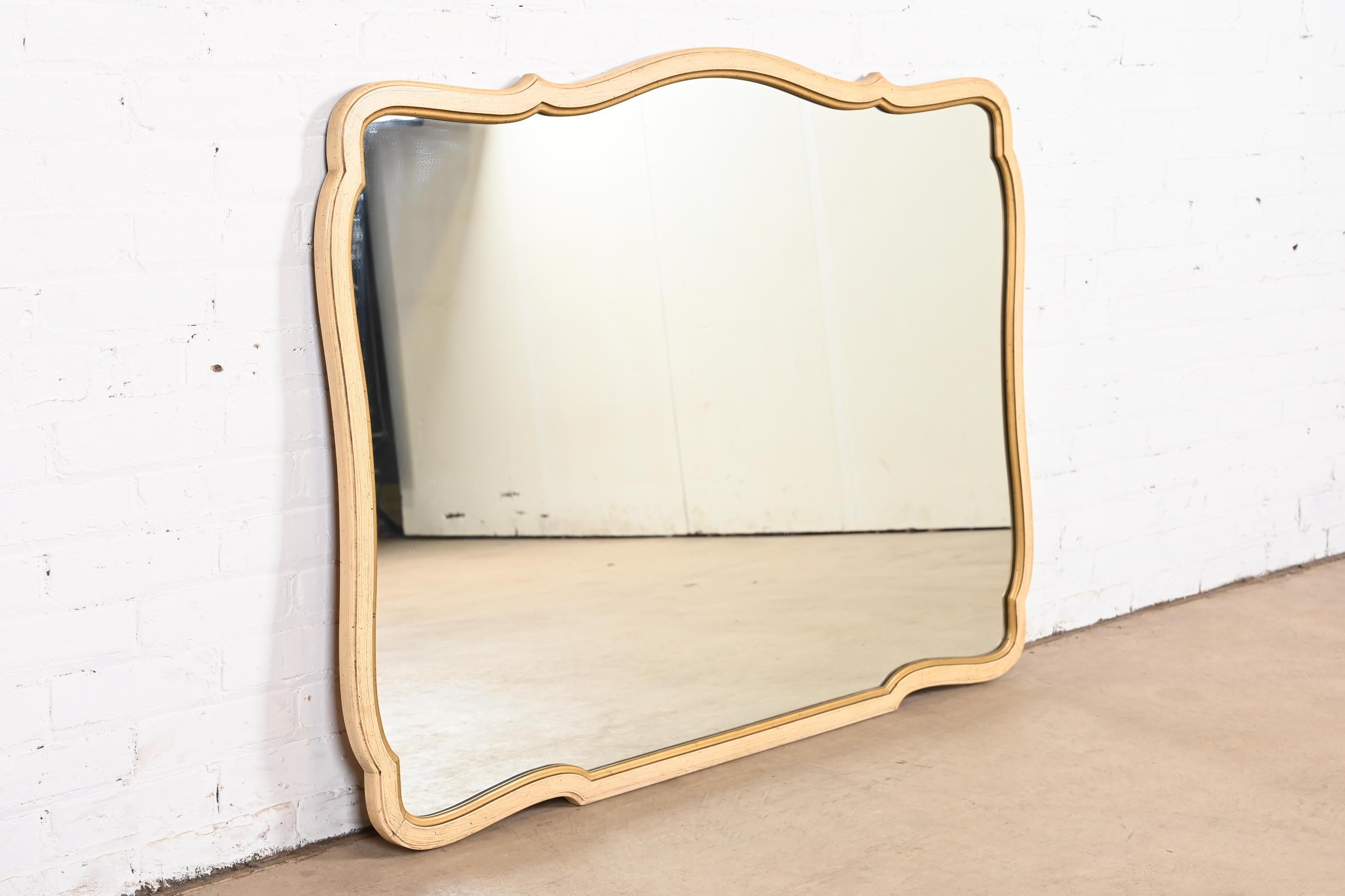 A stylish French Provincial cream and gold gilt painted walnut framed wall mirror

By Henredon

USA, 1960s

Measures: 50.5