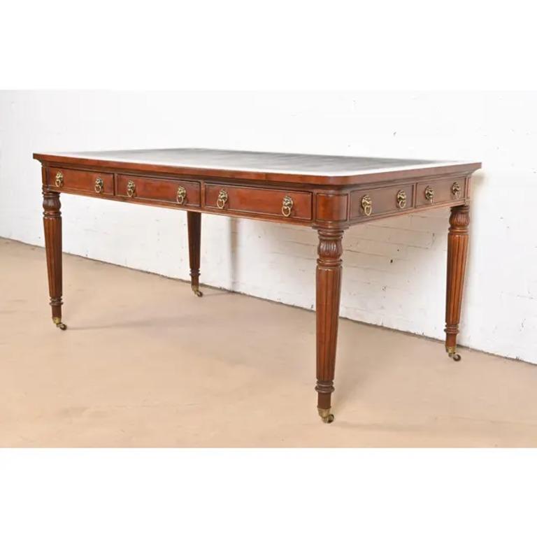 A gorgeous French Regency Louis XVI style executive writing desk or bureau plat desk

By Henredon

USA, Late 20th Century

Carved mahogany, with embossed leather top, original brass lion head mounts and drawer pulls, and brass capped feet on brass