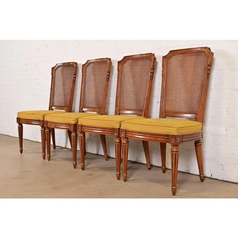 Uno splendido set di quattro sedie da salotto o da pranzo in stile Regency francese Luigi XVI

Da Henredon

USA, circa anni '1960

Cornici in noce massiccio intagliato, con dettagli dorati, schienali a canne e sedili imbottiti.

Misure: 20,5