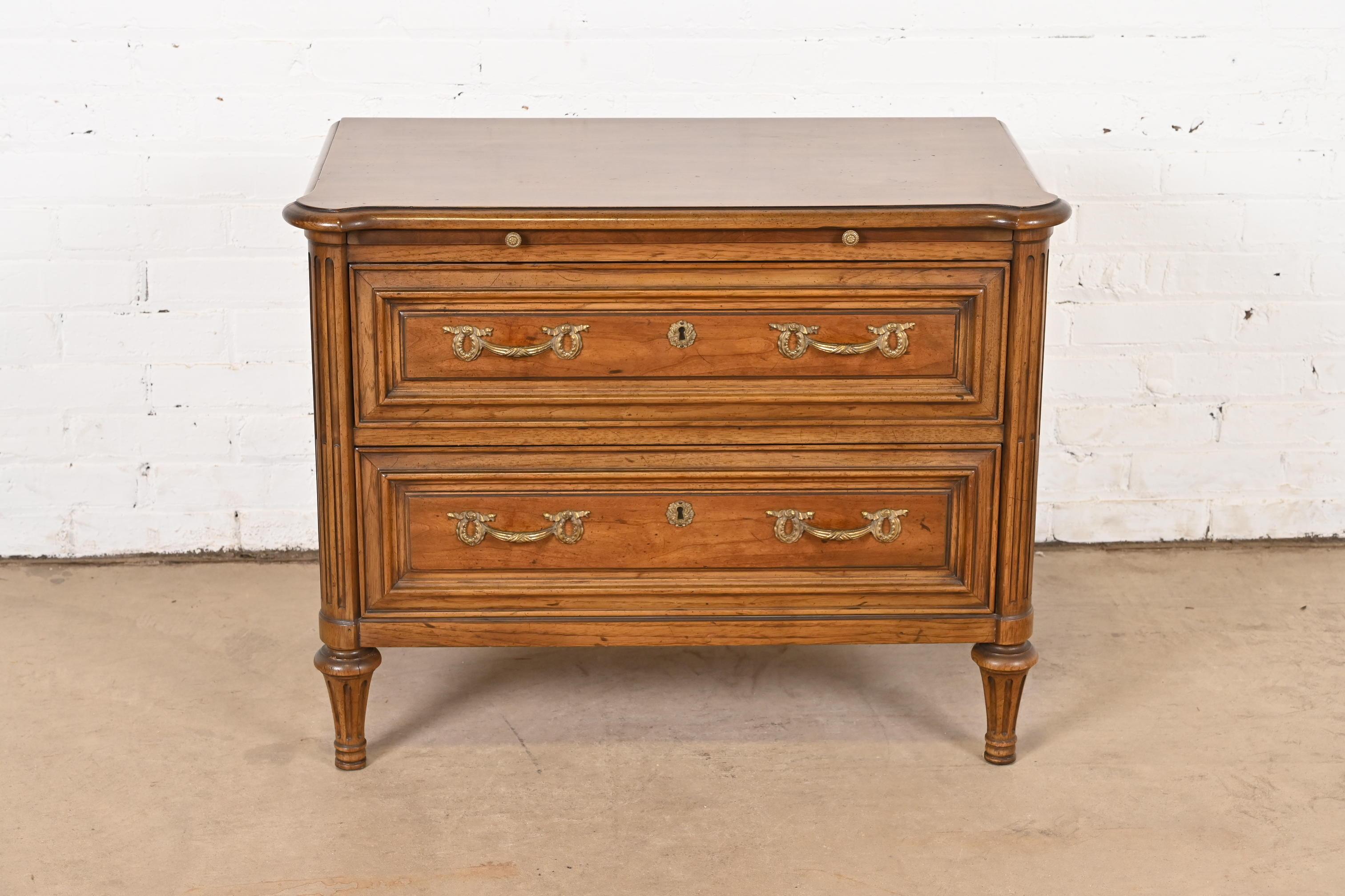 A gorgeous French Regency Louis XVI style chest of drawers or bedside chest

By Henredon

USA, Circa 1960s

Beautiful carved walnut, with original brass hardware.

Measures: 32