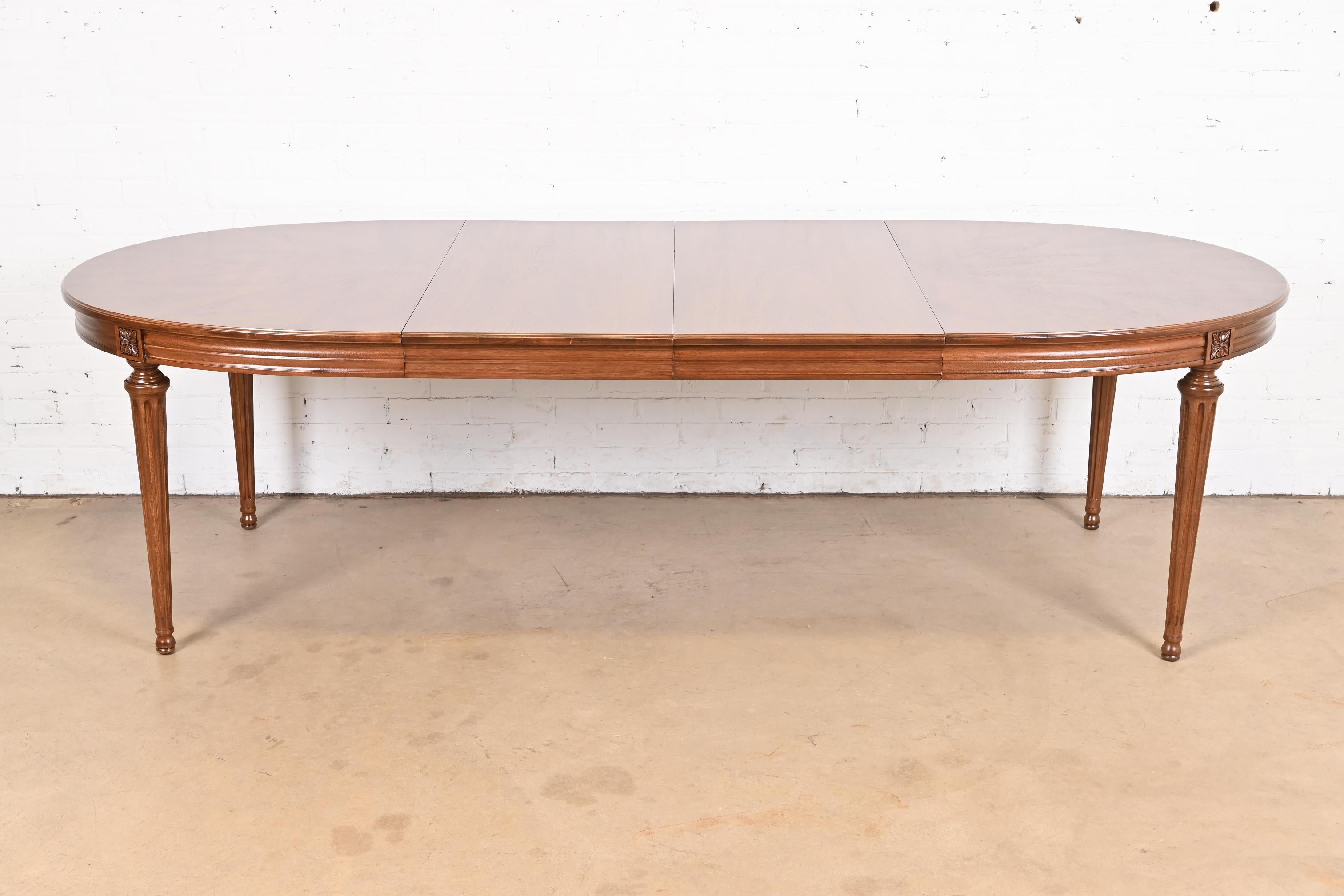 A beautiful French Regency Louis XVI style extension dining table

By Henredon

USA, Circa 1960s

Carved walnut, with gorgeous book-matched starburst walnut top.

Measures: 62