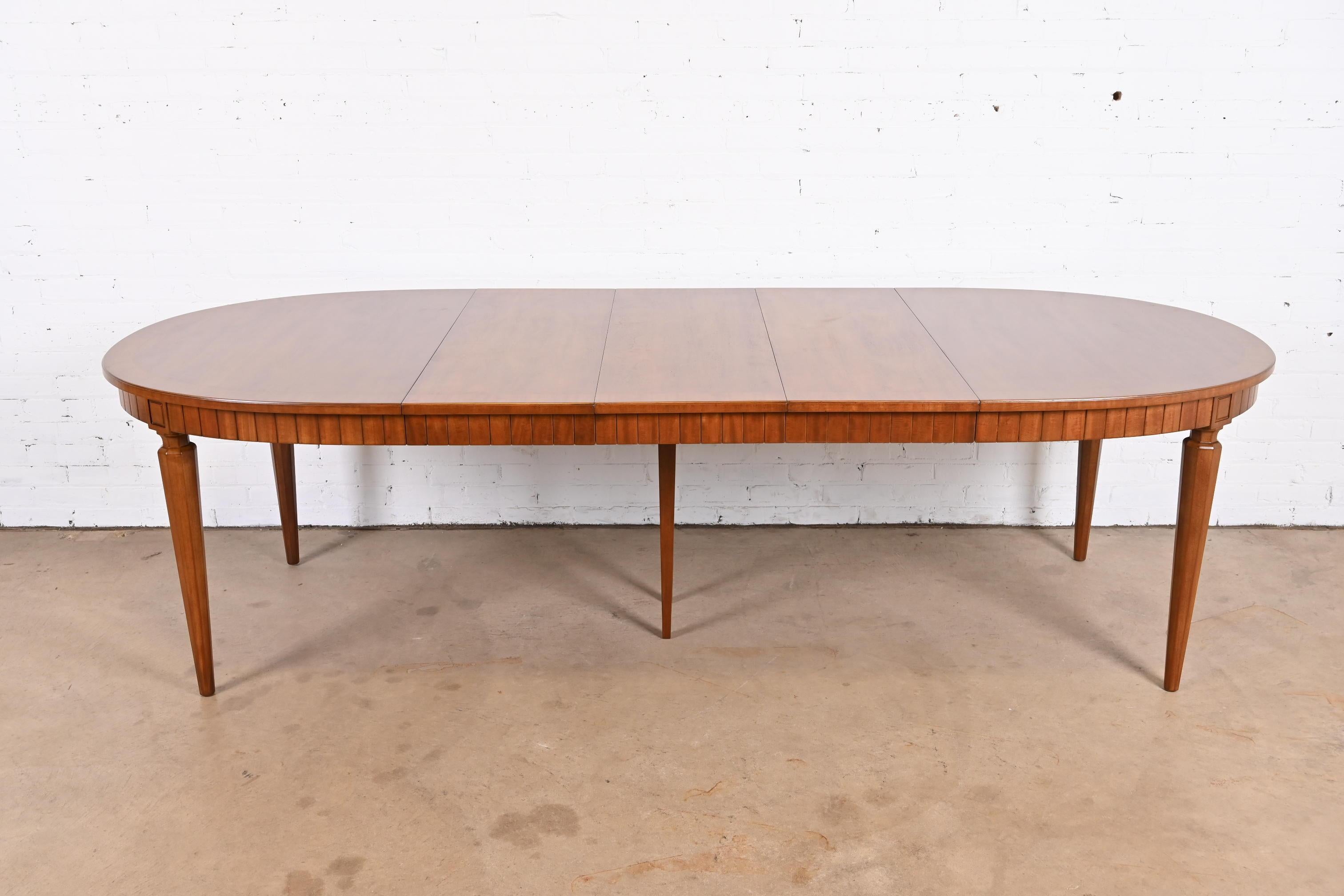 A beautiful French Regency Louis XVI style walnut extension dining table

By Henredon

USA, Circa 1960s

Measures: 60