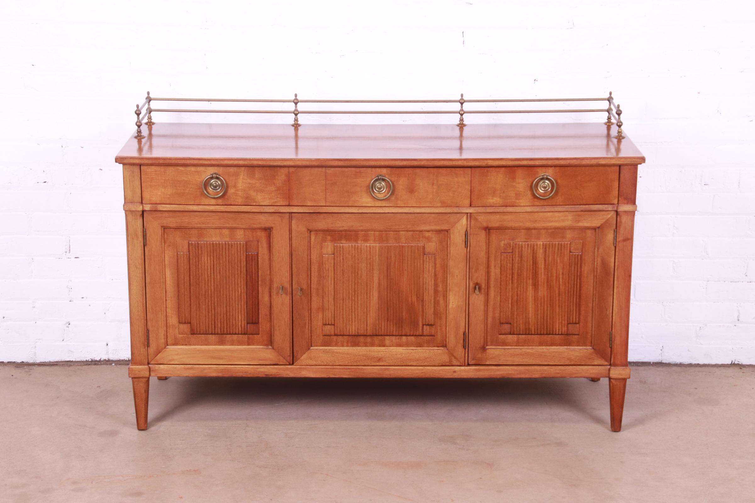A gorgeous mid-century French Regency Louis XVI style sideboard, credenza, or bar cabinet

By Henredon

USA, Circa 1960s

Carved walnut, with original brass hardware and brass gallery.

Measures: 54