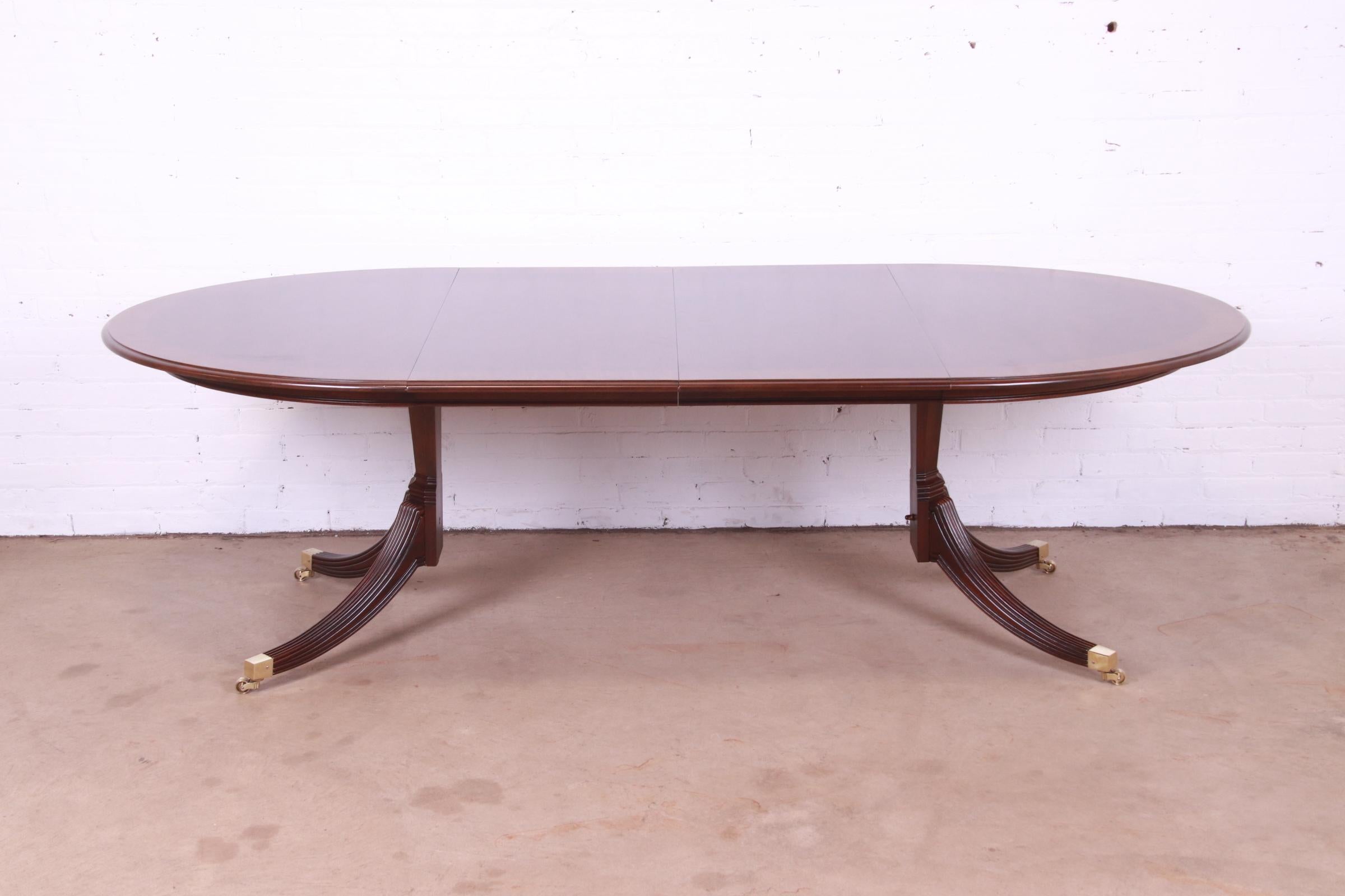 An exceptional Georgian style double pedestal extension dining table

By Henredon

USA, Circa 1980s

Banded mahogany, with carved solid mahogany pedestals, brass-capped feet, and brass casters.

Measures: 54