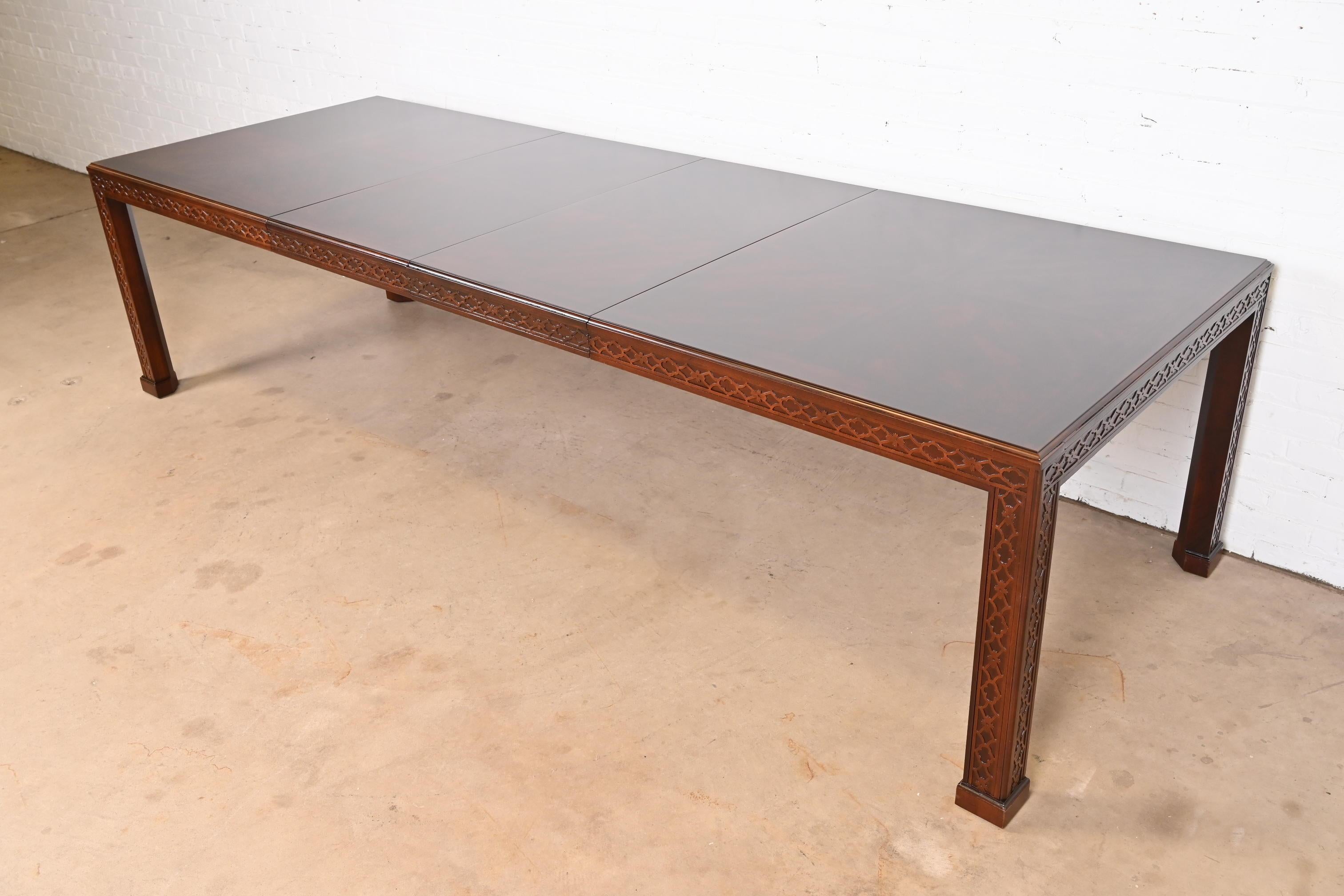 An exceptional Georgian or Chippendale style extension dining table

By Henredon

USA, Circa 1980s

Book-matched mahogany top, with fretwork carved banding and legs.

Measures: 74