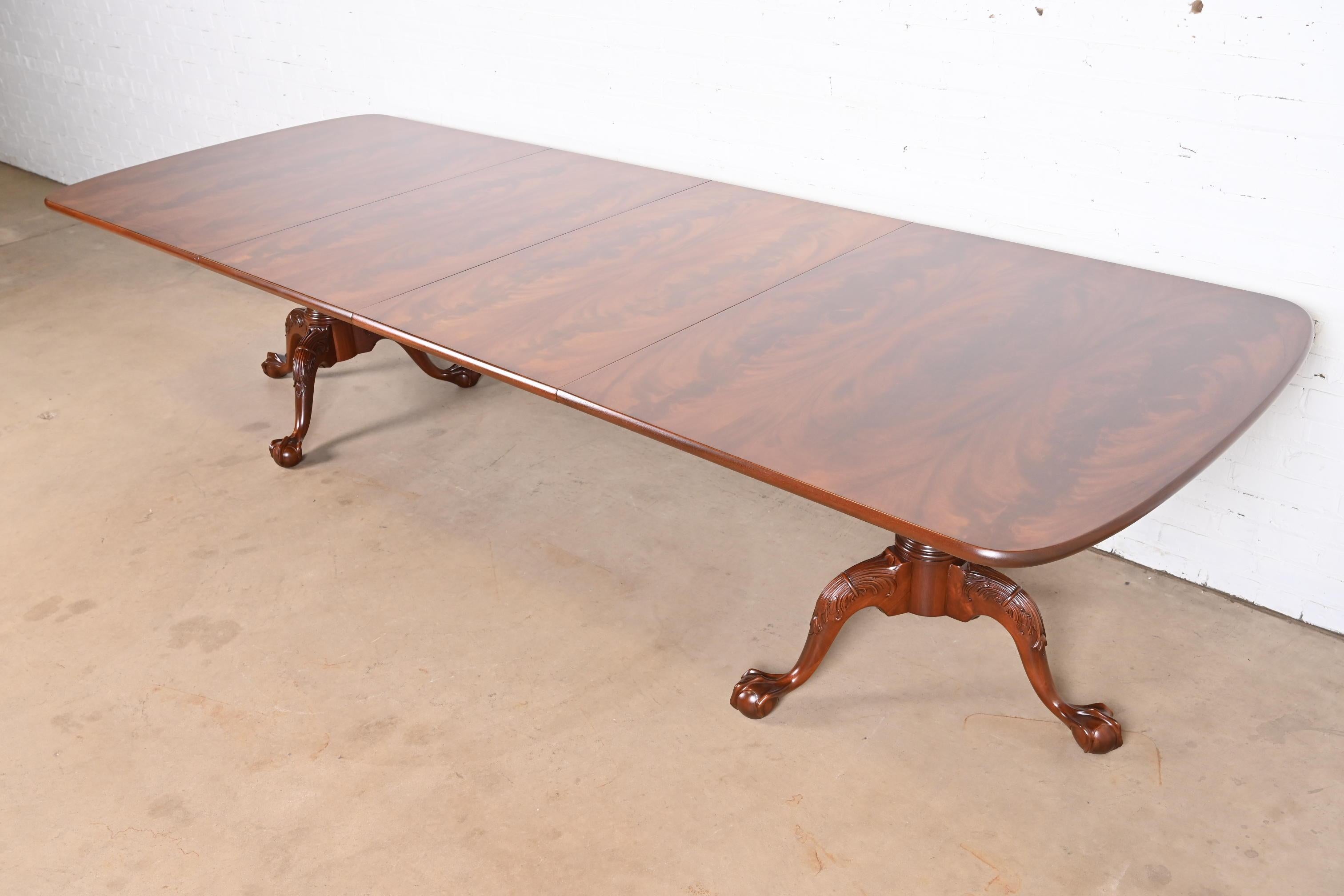 An exceptional Georgian or Chippendale style double pedestal extension dining table

By Henredon

USA, Circa 1980s

Gorgeous book matched flame mahogany top, with carved solid mahogany pedestals and ball and claw feet.

Measures: 76