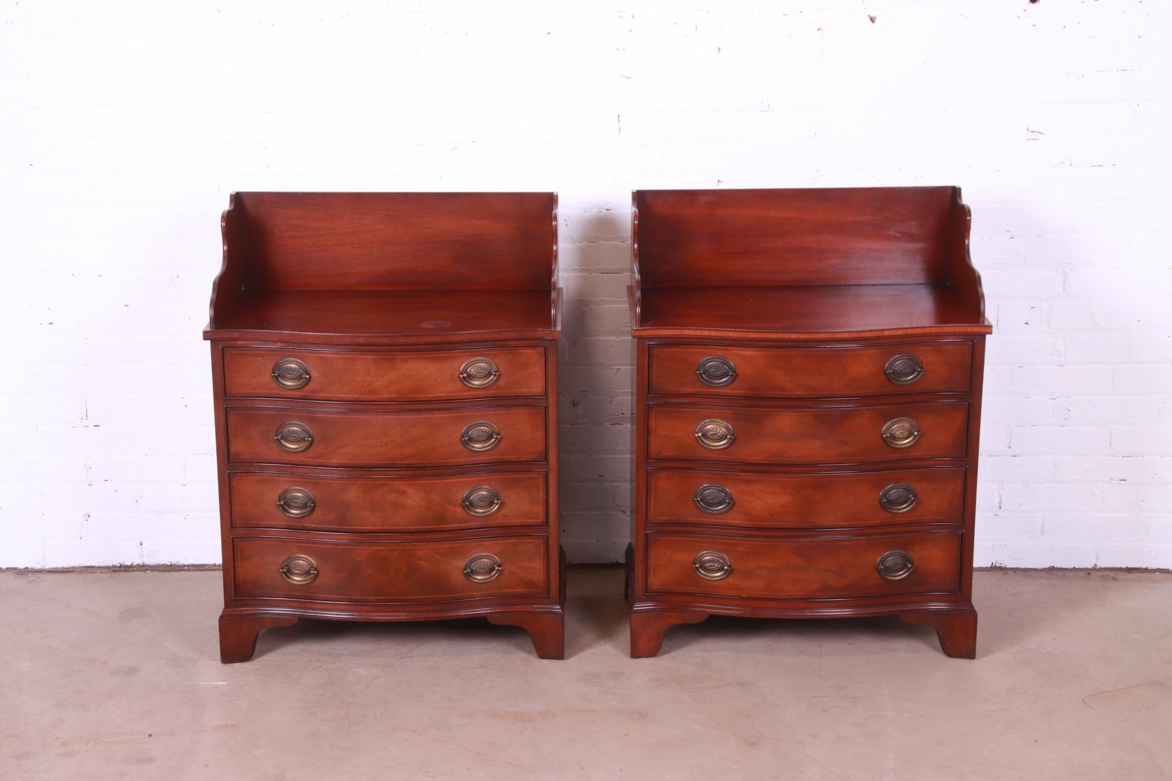 A gorgeous pair of Georgian style serpentine front bachelor chests or bedside chests

By Henredon

USA, Circa 1950s

Mahogany, with satinwood string inlay and original brass hardware.

Measures: 27