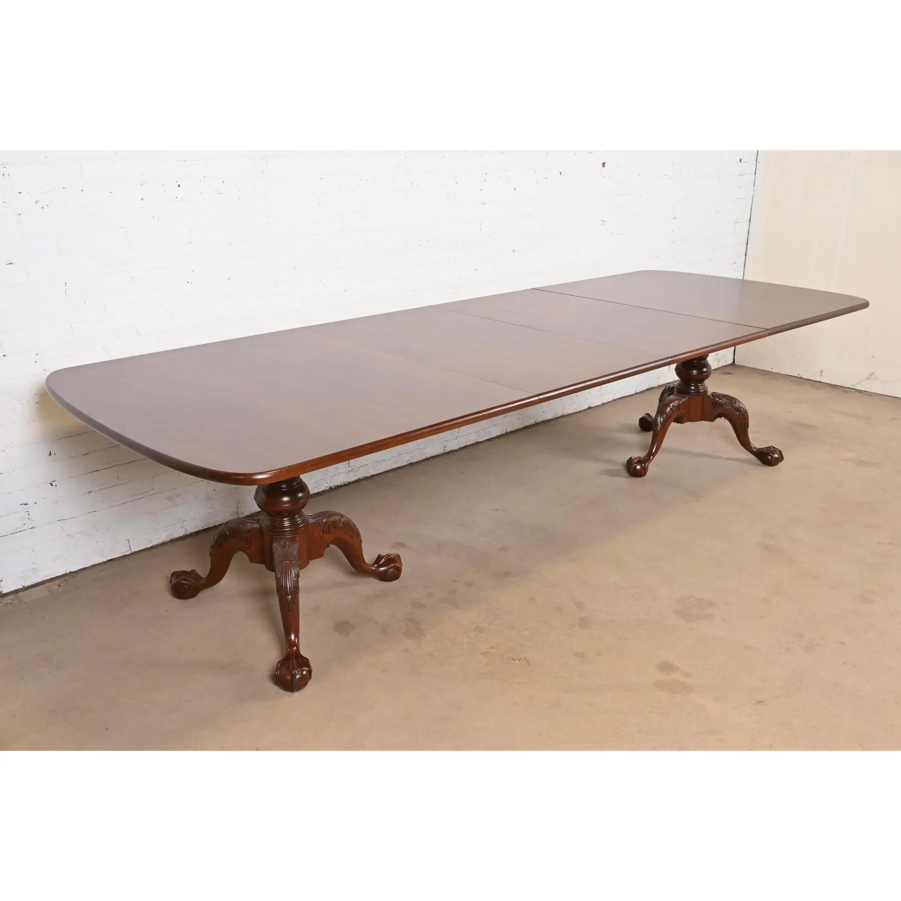 Exceptionnelle table de salle à manger à double piédestal de style géorgien ou Chippendale.

Par Henredon

USA, Circa 1980

Magnifique acajou, avec des piédestaux en acajou massif sculpté et des pieds en forme de boule et de griffe.

Dimensions : 76