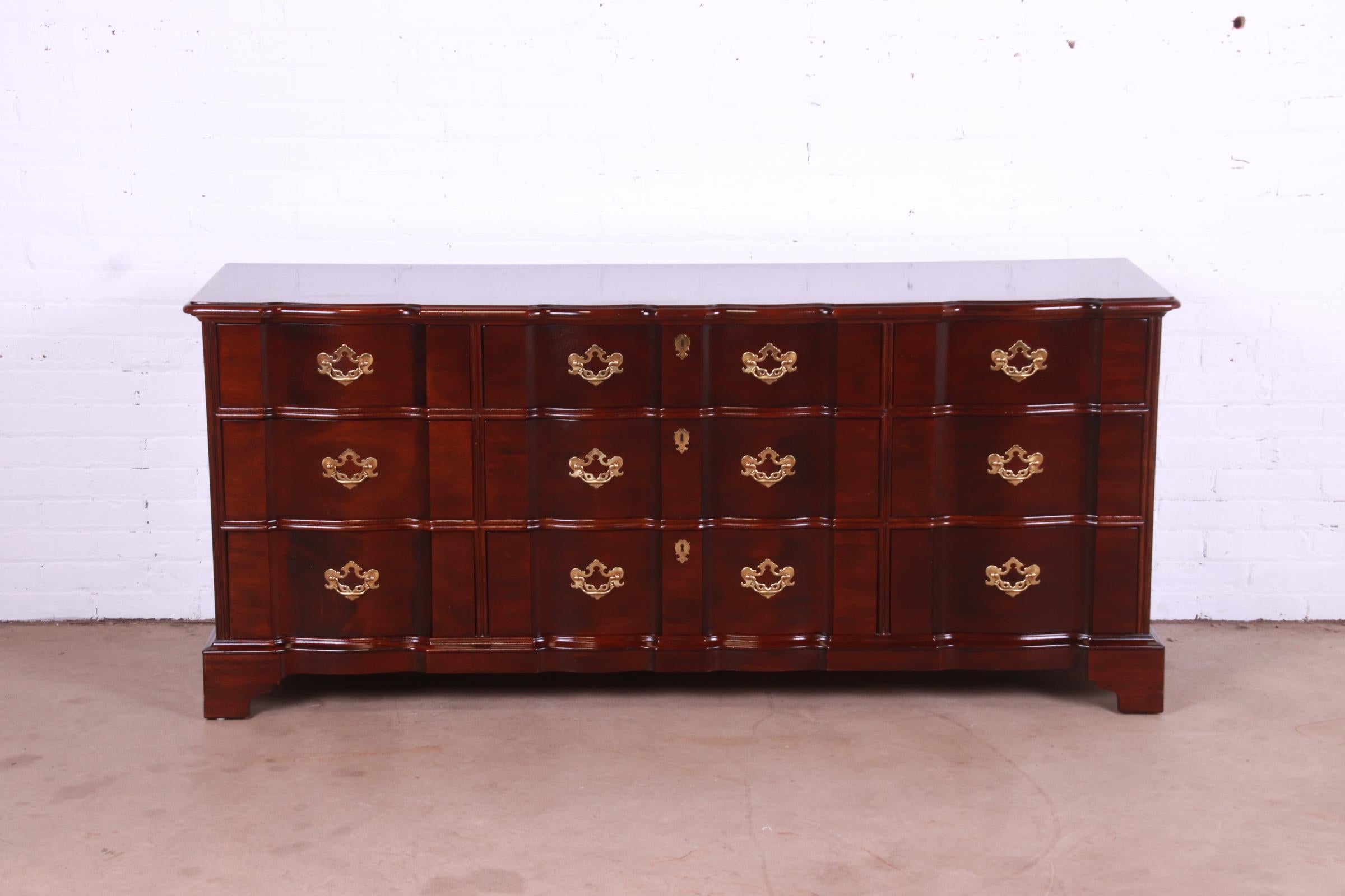 A gorgeous Georgian or Chippendale style block front nine-drawer triple dresser or credenza

By Henredon

USA, Circa 1980s

Solid carved mahogany, with original brass hardware.

Measures: 71.5