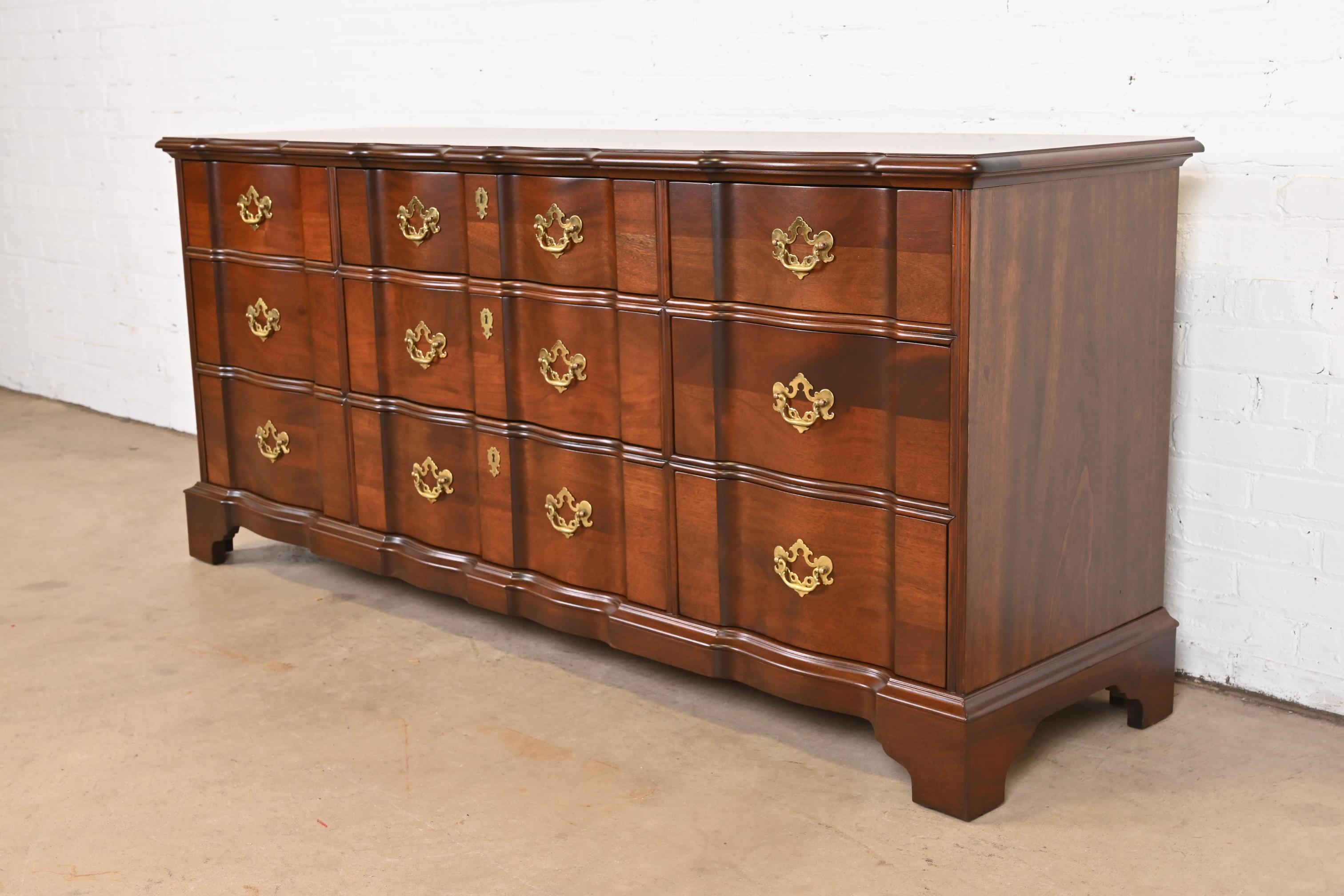 A gorgeous Georgian or Chippendale style block front nine-drawer triple dresser or credenza

By Henredon

USA, Circa 1980s

Solid carved mahogany, with original brass hardware.

Measures: 71.5