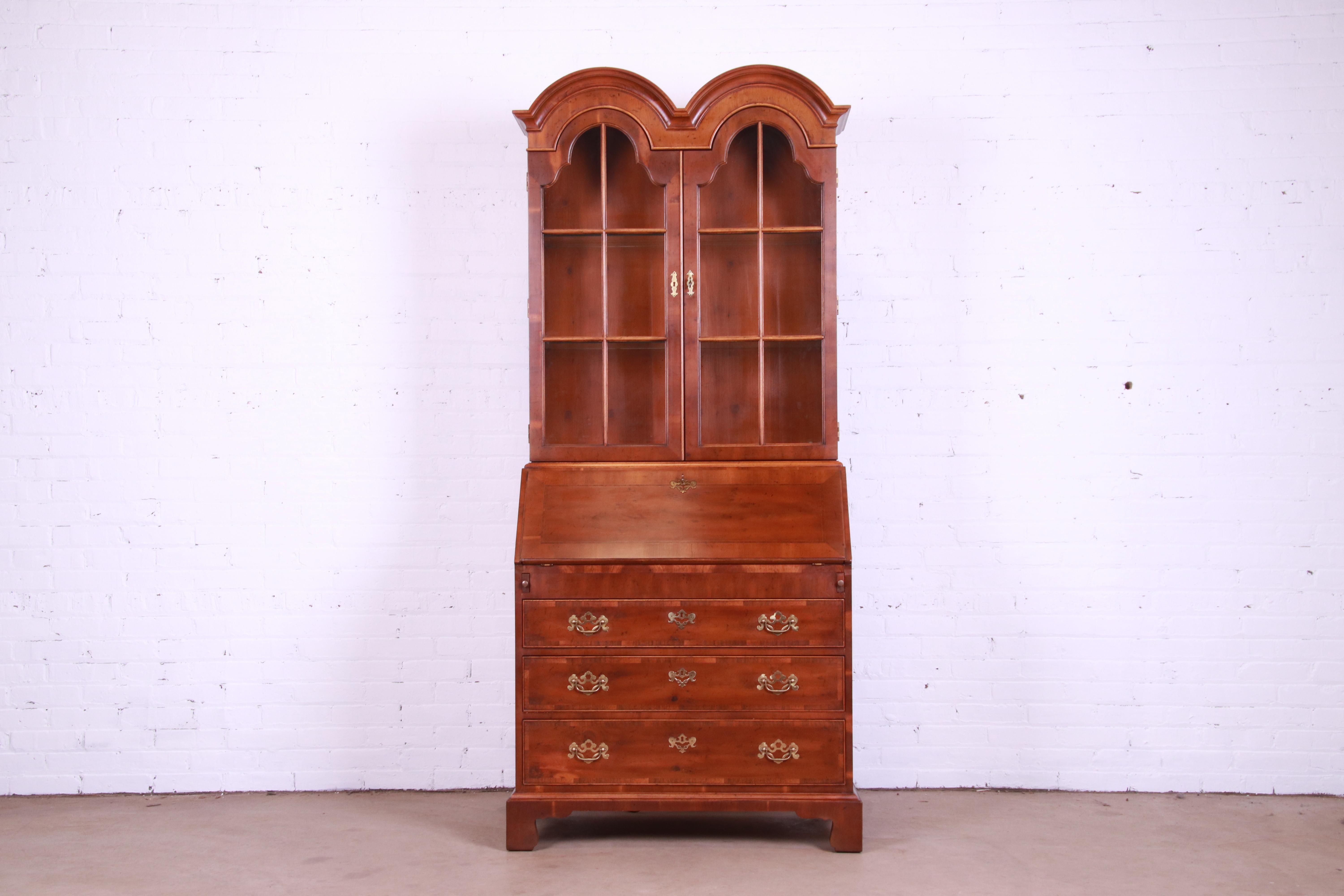 A gorgeous Georgian style bureau with drop front secretary desk and bookcase hutch top

By Henredon

USA, Circa 1980s

Banded yew wood, with original brass hardware, mullioned glass front doors, and lighted top cabinet.

Measures: 36.25