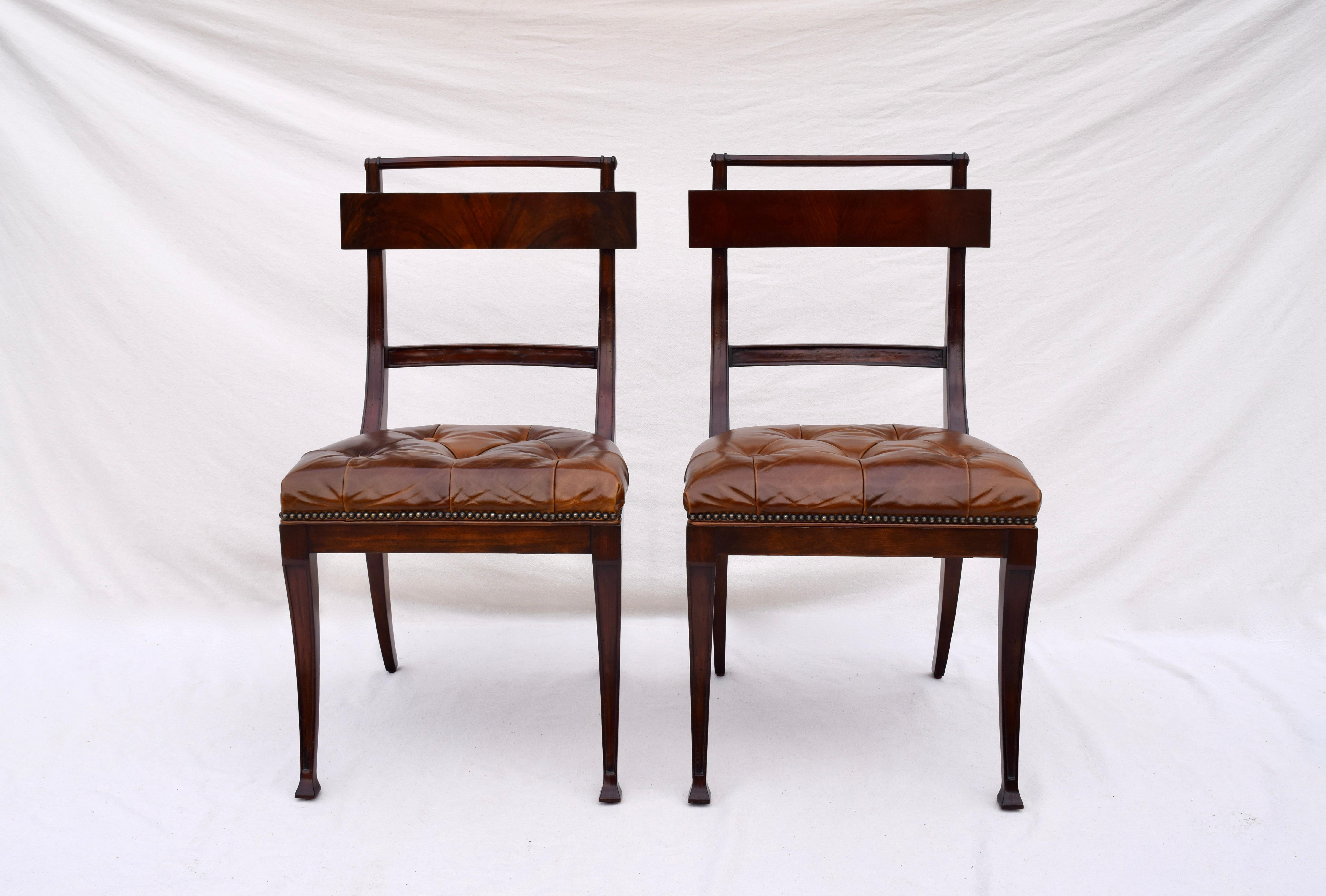 A pair of Henredon antique styled dining chairs, Federal period inspired. Channeled, flame mahogany frame of long slender curves, upholstered in tufted aniline leather with brass tack accents. From Henredon's Acquisitions Collection, we love the