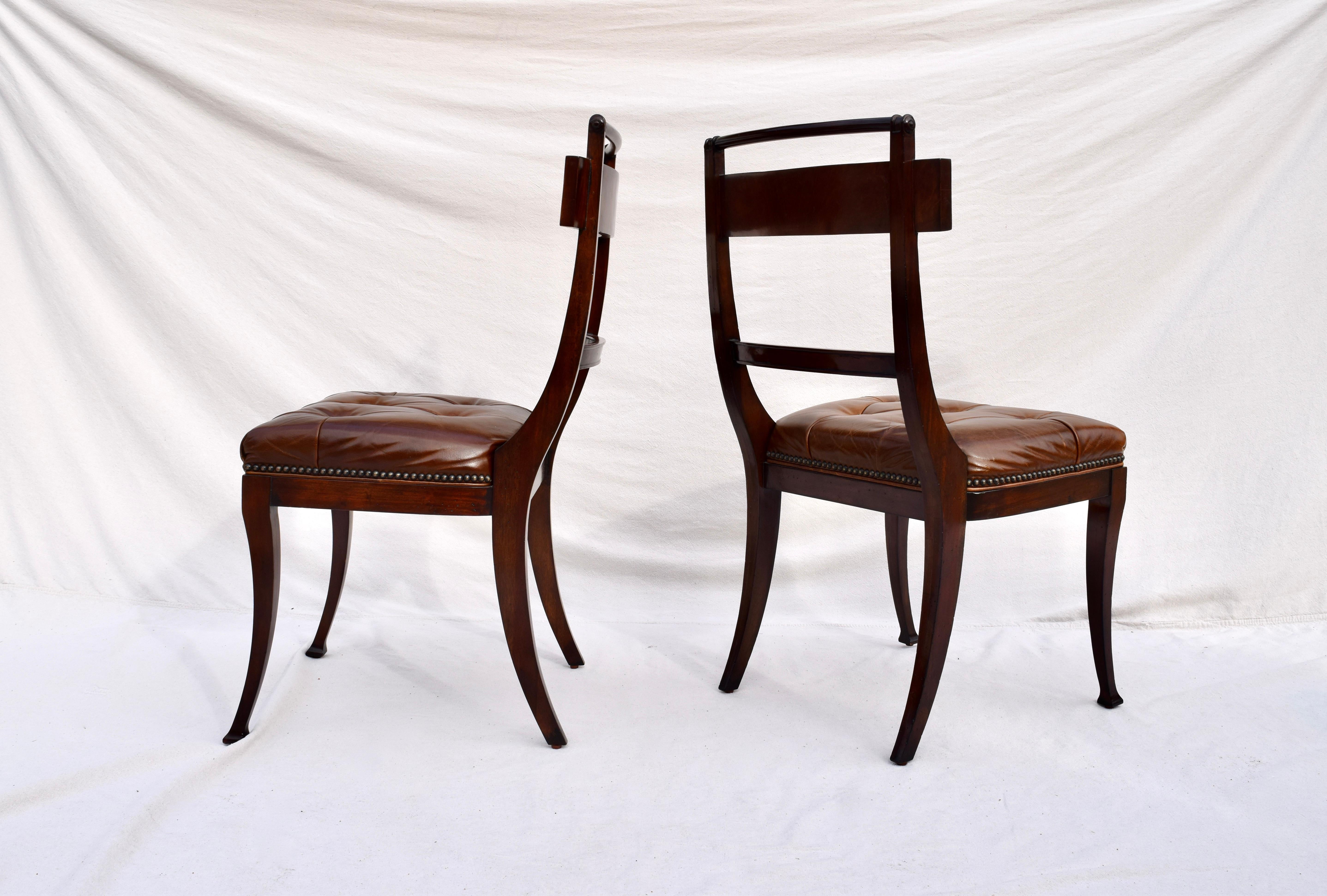 A pair of Henredon antique styled dining chairs, federal period inspired. Channeled, flame mahogany frame of long slender curves, upholstered in rich aniline leather with brass tack accents. From Henredon's Acquisitions collection, we love the