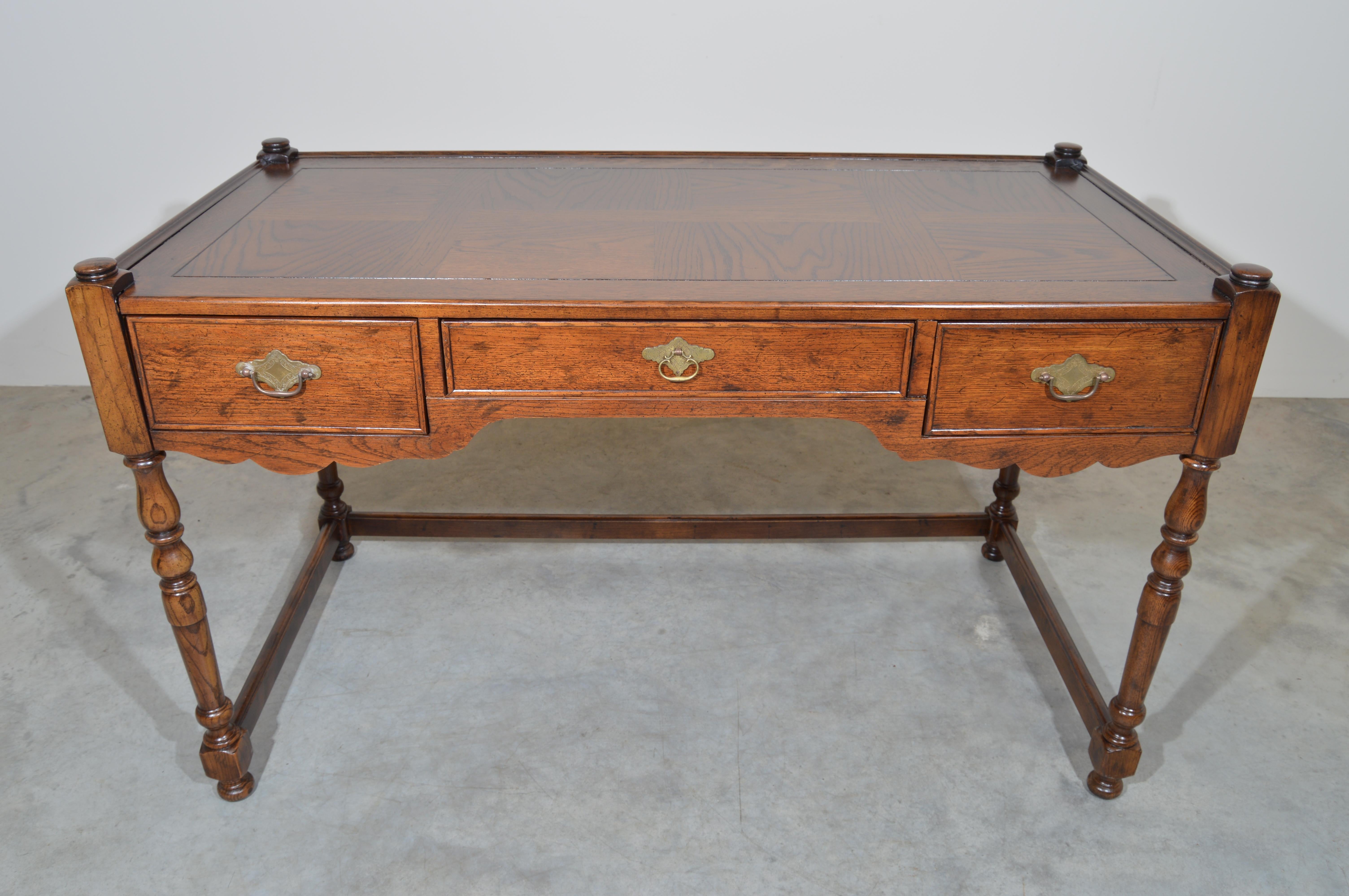 A beautiful Henredon Heritage Walnut Writing Desk having turned legs with classic carved features throughout. A classic regency workspace designed to save space and look gorgeous. Each drawer features antique regency brass pulls with the center