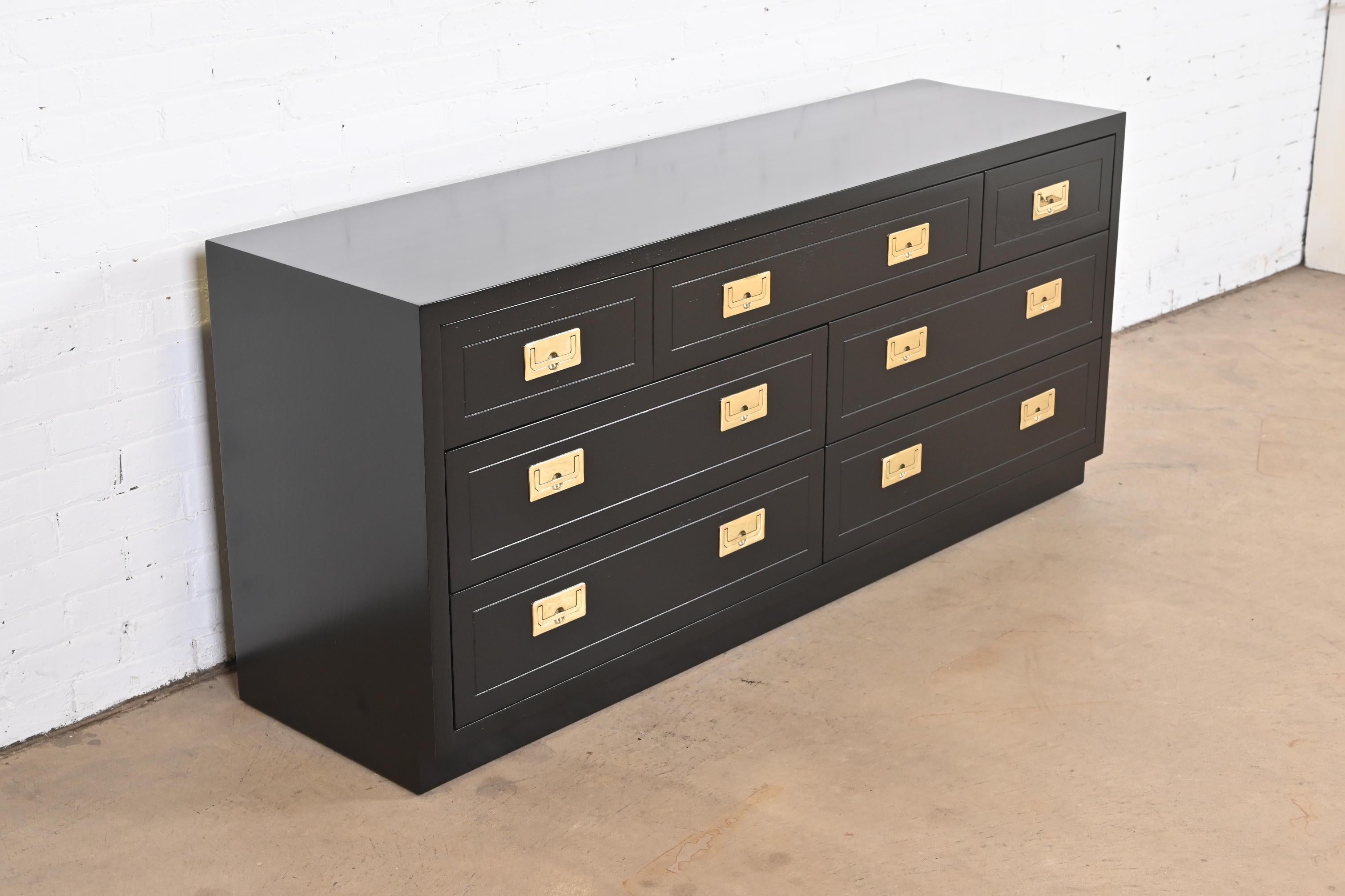 An exceptional mid-century modern Hollywood Regency Campaign style seven-drawer dresser or credenza

By Henredon

USA, Circa 1970s

Black lacquered walnut, with original brass hardware.

Measures: 64