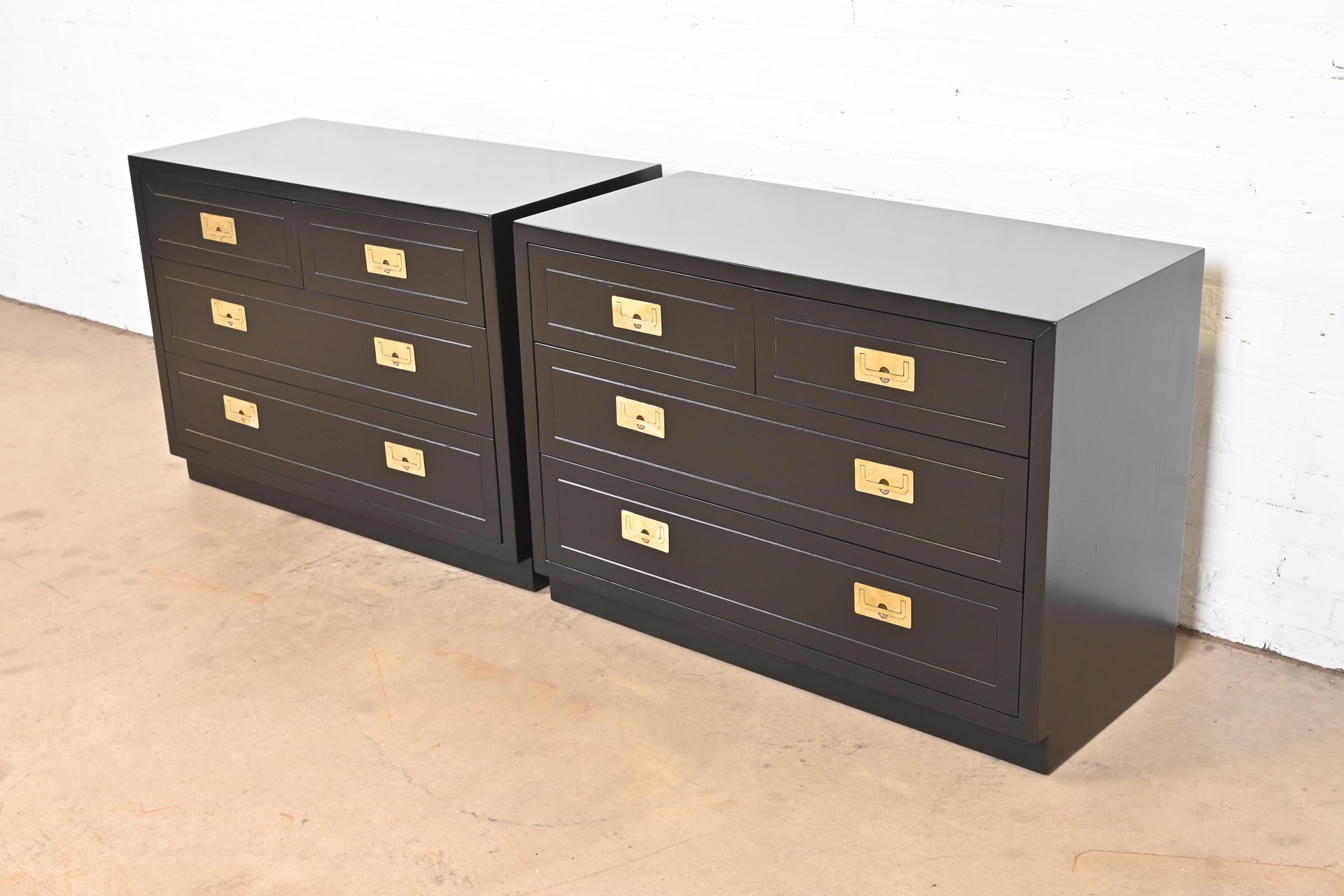A gorgeous pair of mid-century modern Hollywood Regency Campaign style dressers or chests of drawers

By Henredon

USA, Circa 1970s

Black lacquered walnut, with original brass hardware

Measures: 40