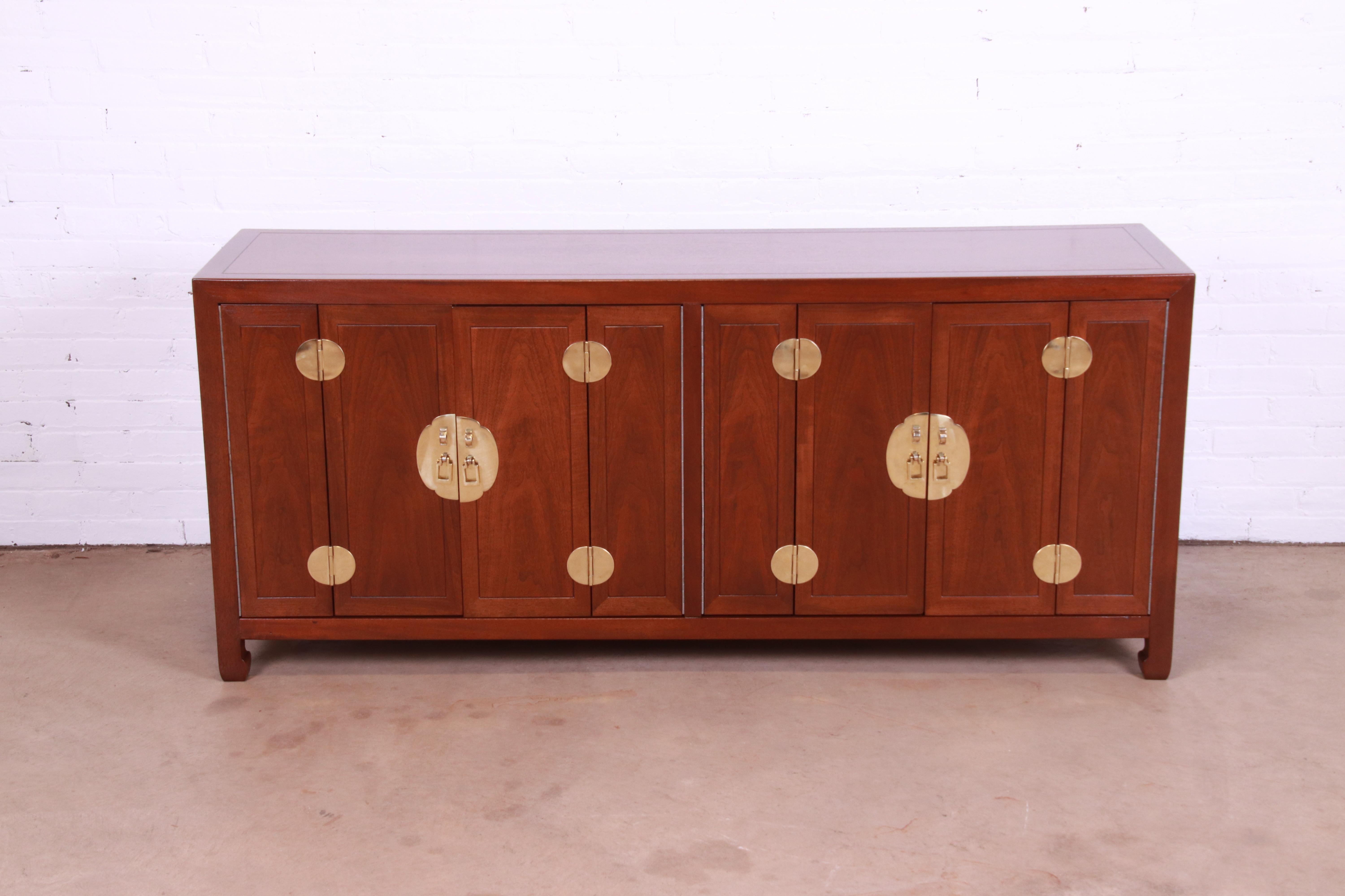 An exceptional mid-century Hollywood Regency Chinoiserie sideboard, credenza, or bar cabinet

By Henredon

USA, circa 1970s

Book-matched mahogany, with Asian-inspired brass hardware and accents.

Measures: 70
