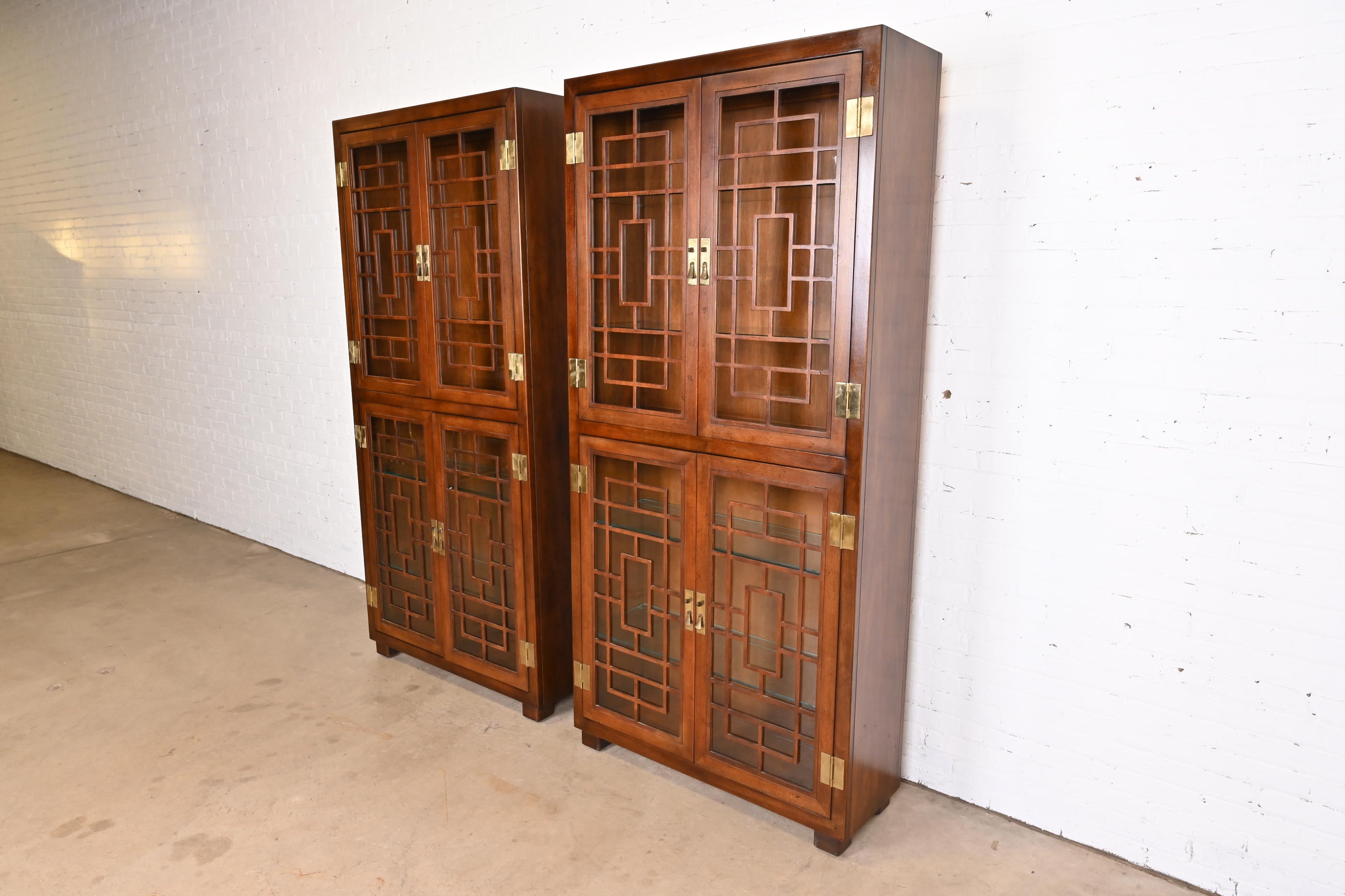 A gorgeous pair of Hollywood Regency Chinoiserie Campaign style lighted display cabinets, bookcases, or china cabinets

By Henredon

USA, Circa 1970s

Mahogany, with mullioned glass front doors and original brass hardware.

Measures: 40