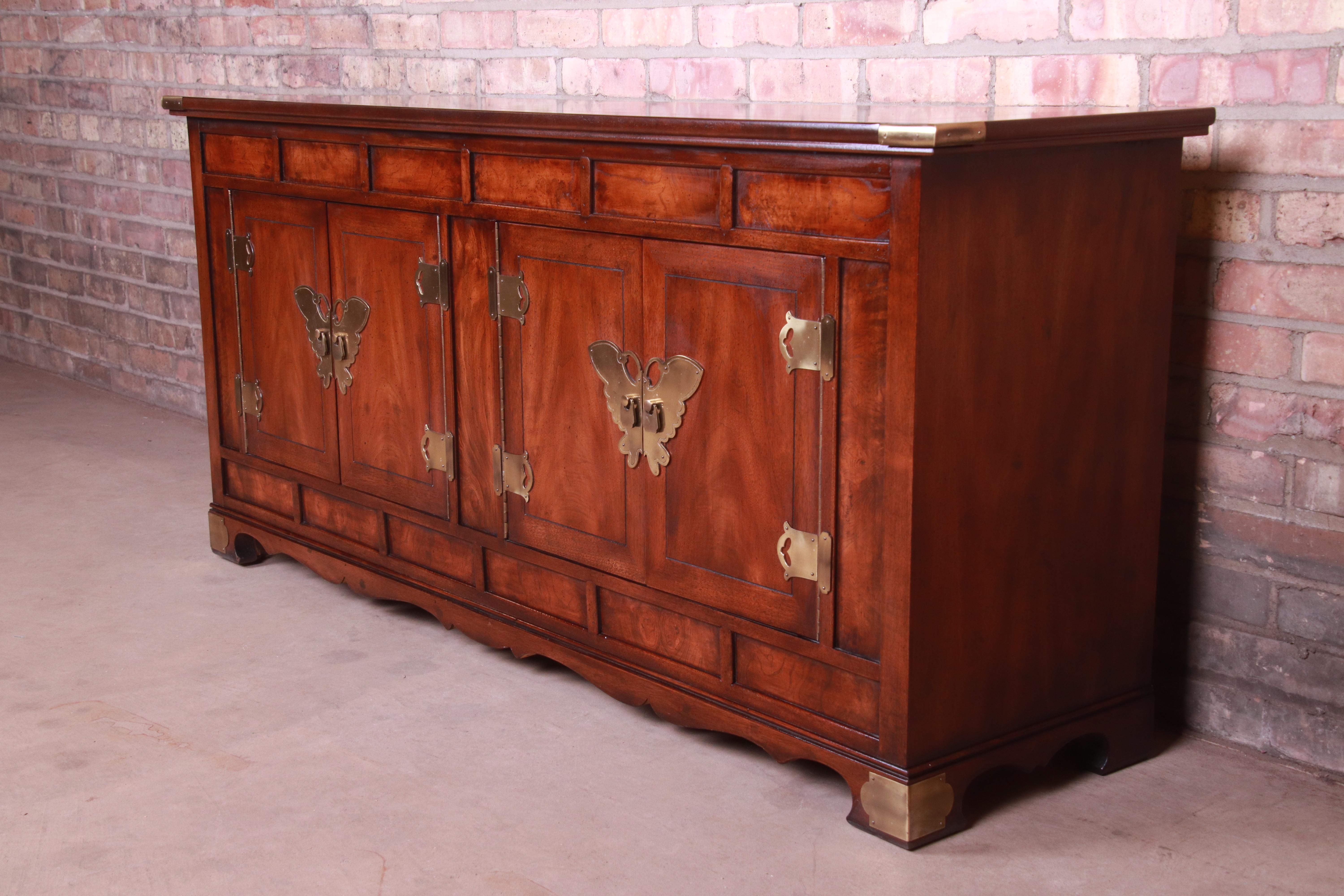 An exceptional Hollywood Regency chinoiserie sideboard, credenza, or bar cabinet

By Henredon

USA, circa 1970s

Bookmatched mahogany, with original brass butterfly hardware.

Measures: 60