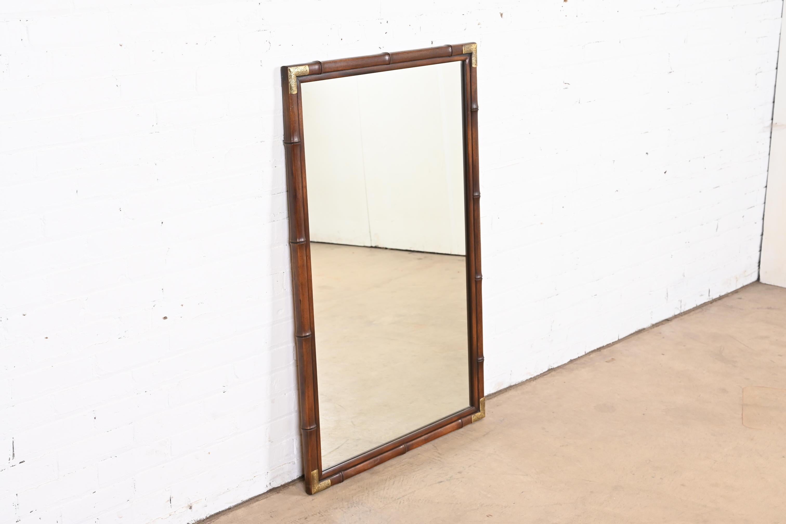 A gorgeous mid-century modern Hollywood Regency Chinoiserie style framed wall mirror

By Henredon

USA, 1970s

Bamboo form walnut frame, with brass hardware.

Measures: 29