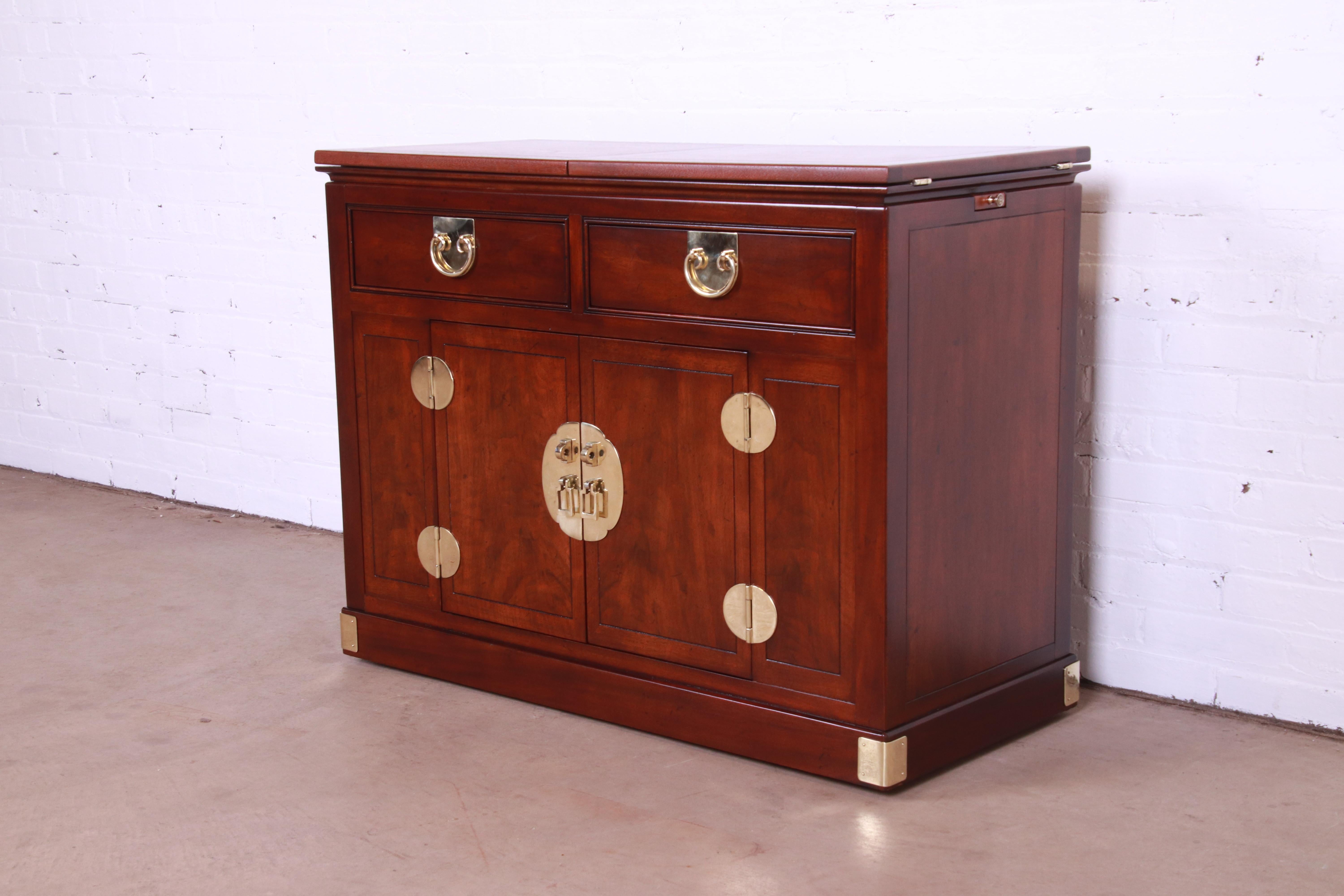 An exceptional mid-century modern Hollywood Regency Chinoiserie style rolling server or bar cart with extending top

By Henredon

USA, Circa 1970s

Walnut, with original Asian-inspired brass hardware.

Measures: 40