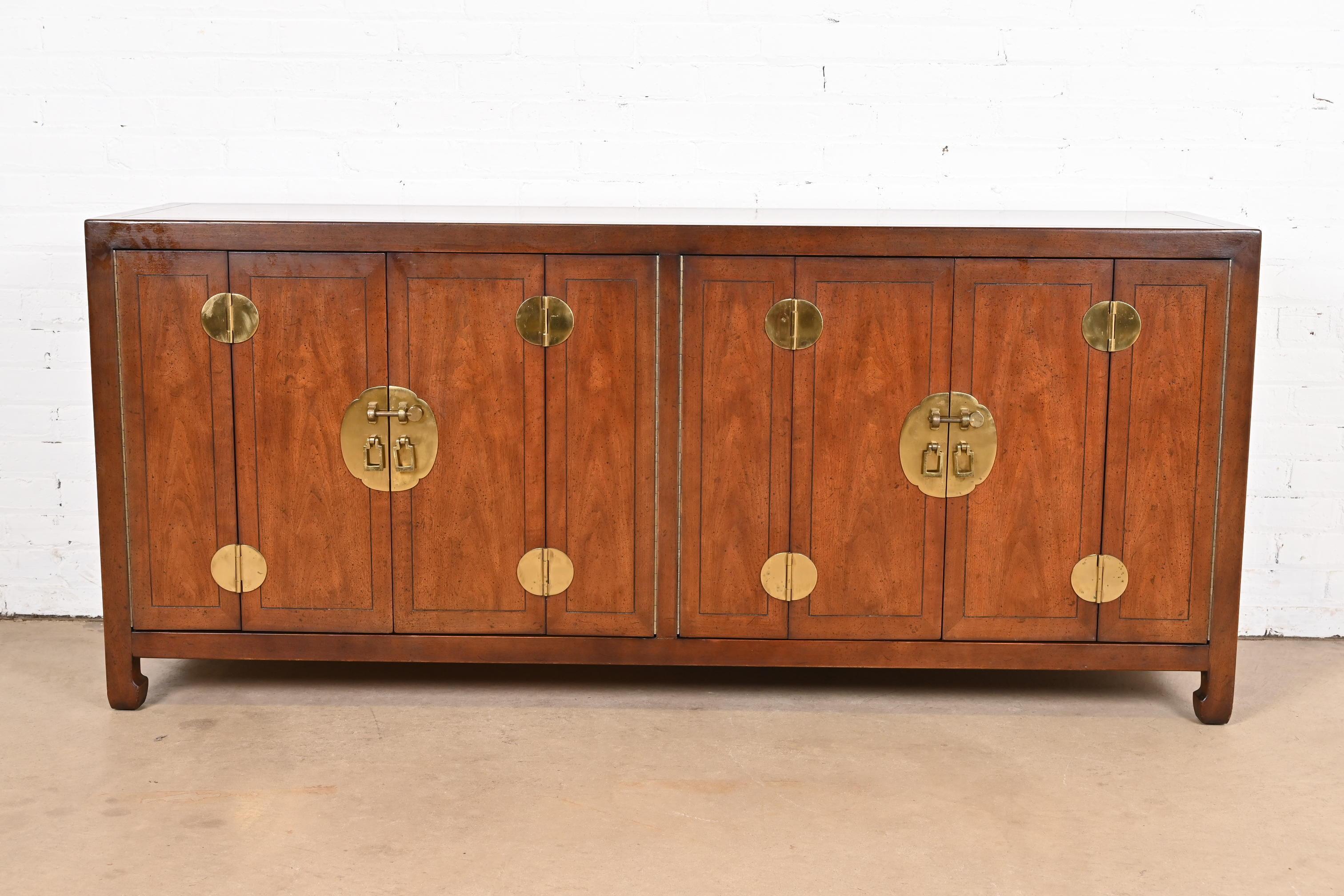 An exceptional mid-century Hollywood Regency Chinoiserie sideboard, credenza, or bar cabinet

By Henredon

USA, Circa 1970s

Beautiful book-matched walnut, with Asian-inspired brass hardware and accents. Interior shelves are adjustable.

Measures: