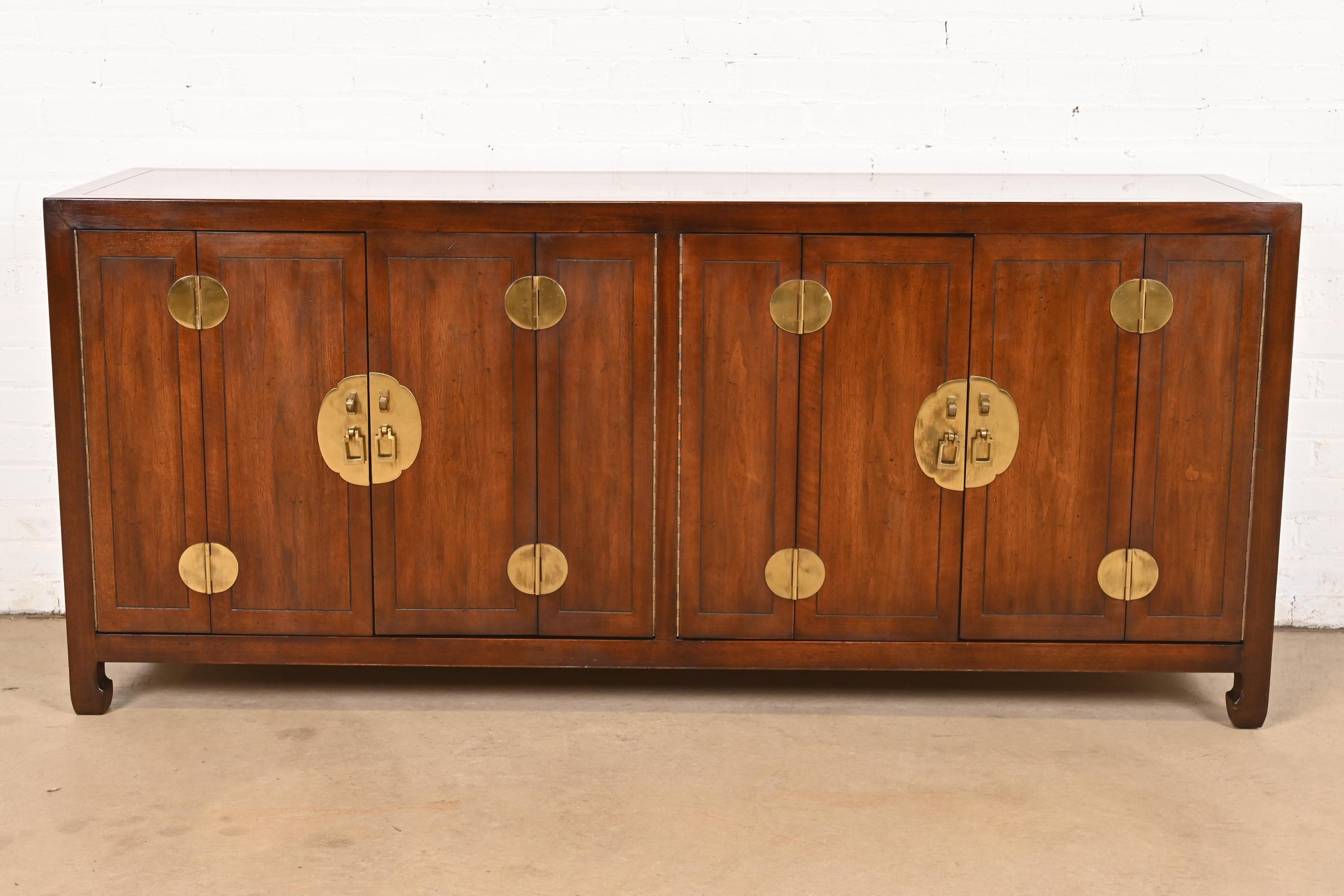 An exceptional mid-century Hollywood Regency Chinoiserie sideboard, credenza, or bar cabinet

By Henredon

USA, Circa 1970s

Beautiful walnut, with Asian-inspired brass hardware and accents. Interior shelves are adjustable.

Measures: 70