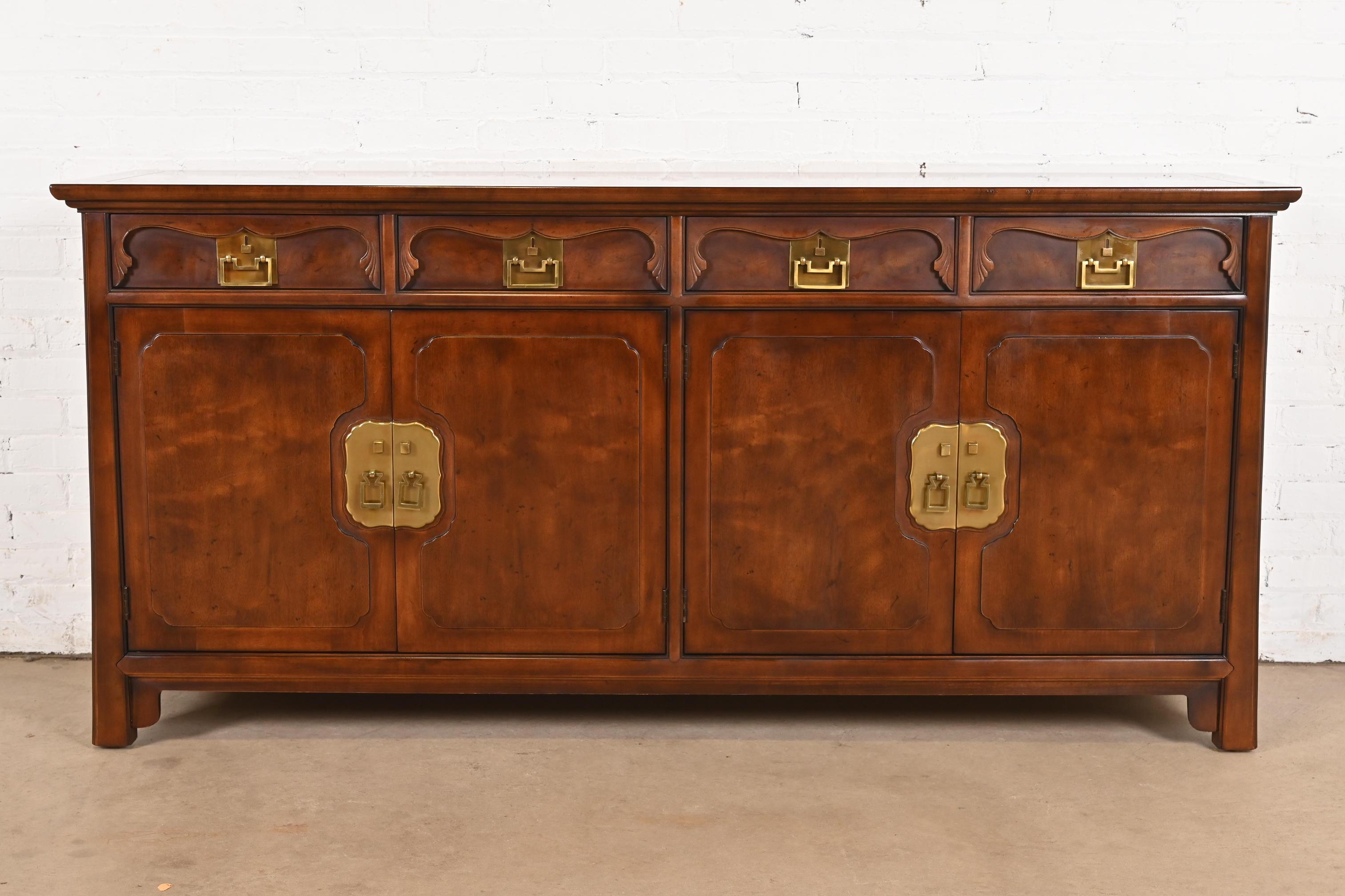 An exceptional mid-century Hollywood Regency Chinoiserie sideboard, credenza, or bar cabinet

By Henredon

USA, Circa 1970s

Beautiful sculpted walnut, with Asian-inspired brass hardware.

Measures: 72