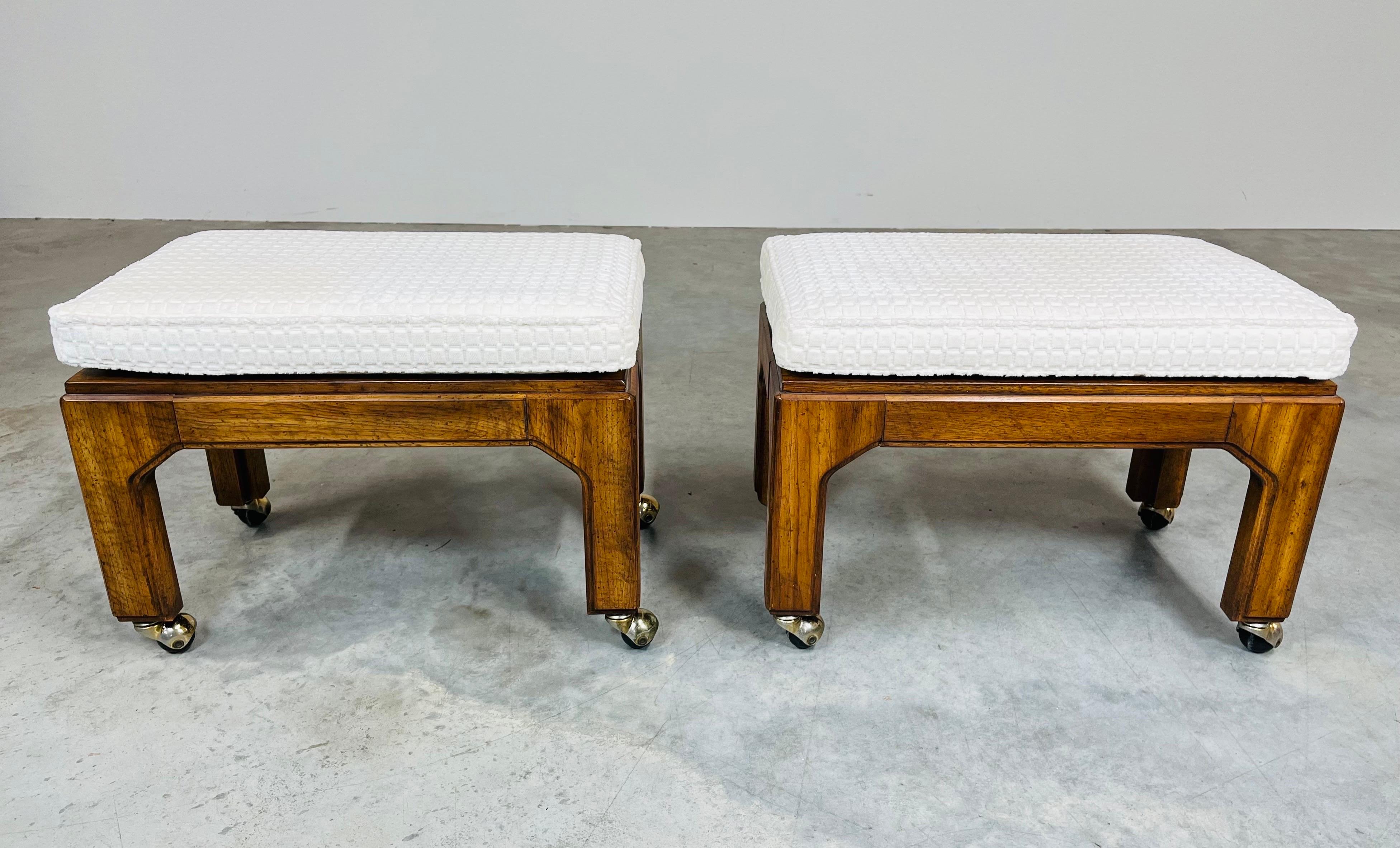 An elegant pair of Hollywood Regency stools in solid mahogany over ball casters having removable soft off white cushions attributed to Henredon. 
In excellent vintage condition having no damage. Cushions are clean and fresh. 
17x23x14” HWD SH 17”