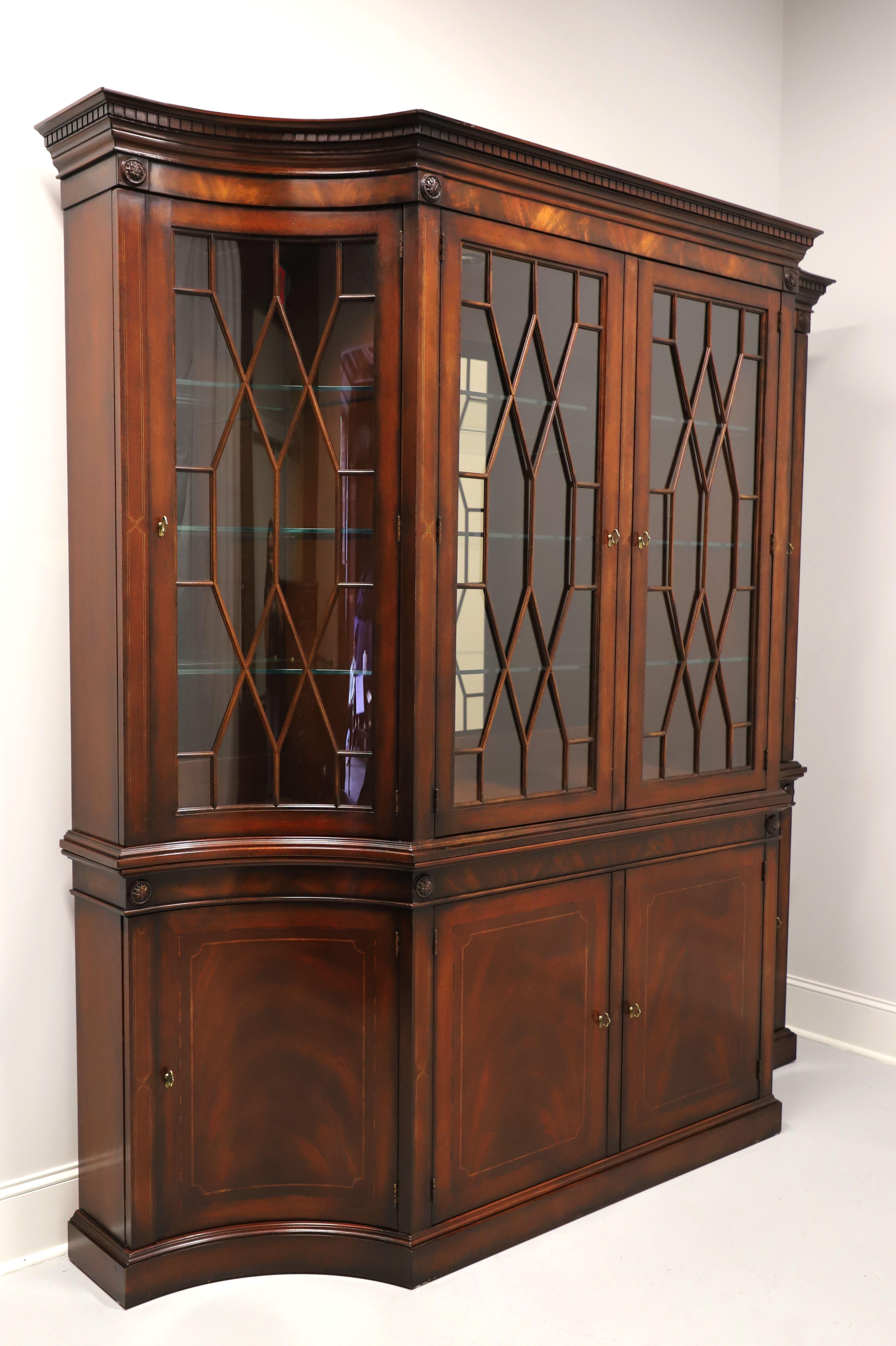 A china display cabinet in the Regency style by Henredon. Mahogany with inlaid flame mahogany, unique curved inward sides breakfront design, distinctive crown molding with dentils, brass hardware & brass medallion ornamentation, ogee edge at middle