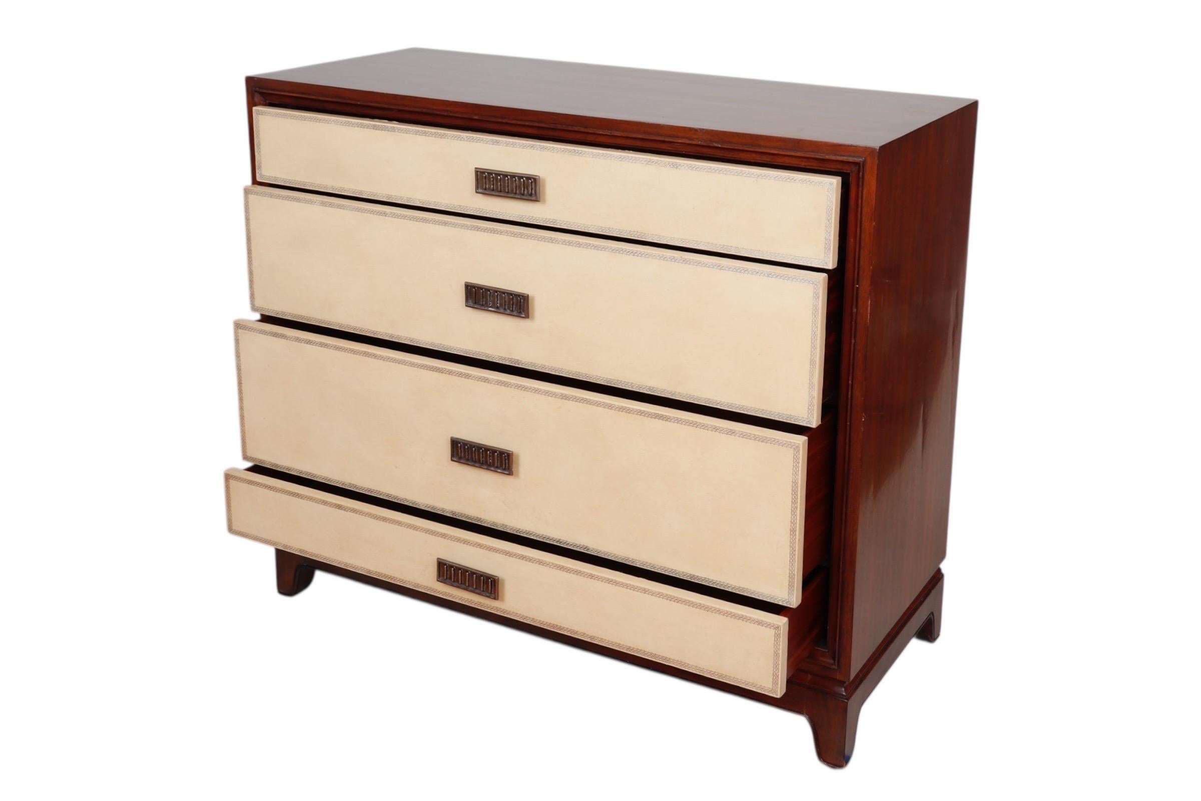 A contemporary Henredon chest of drawers. Four drawers with off-white leather wrapped drawer fronts, decorated with a silver tooled border, open with pressed metal bar handles. Stands on beveled bracket feet. Maker's label in top drawer.
