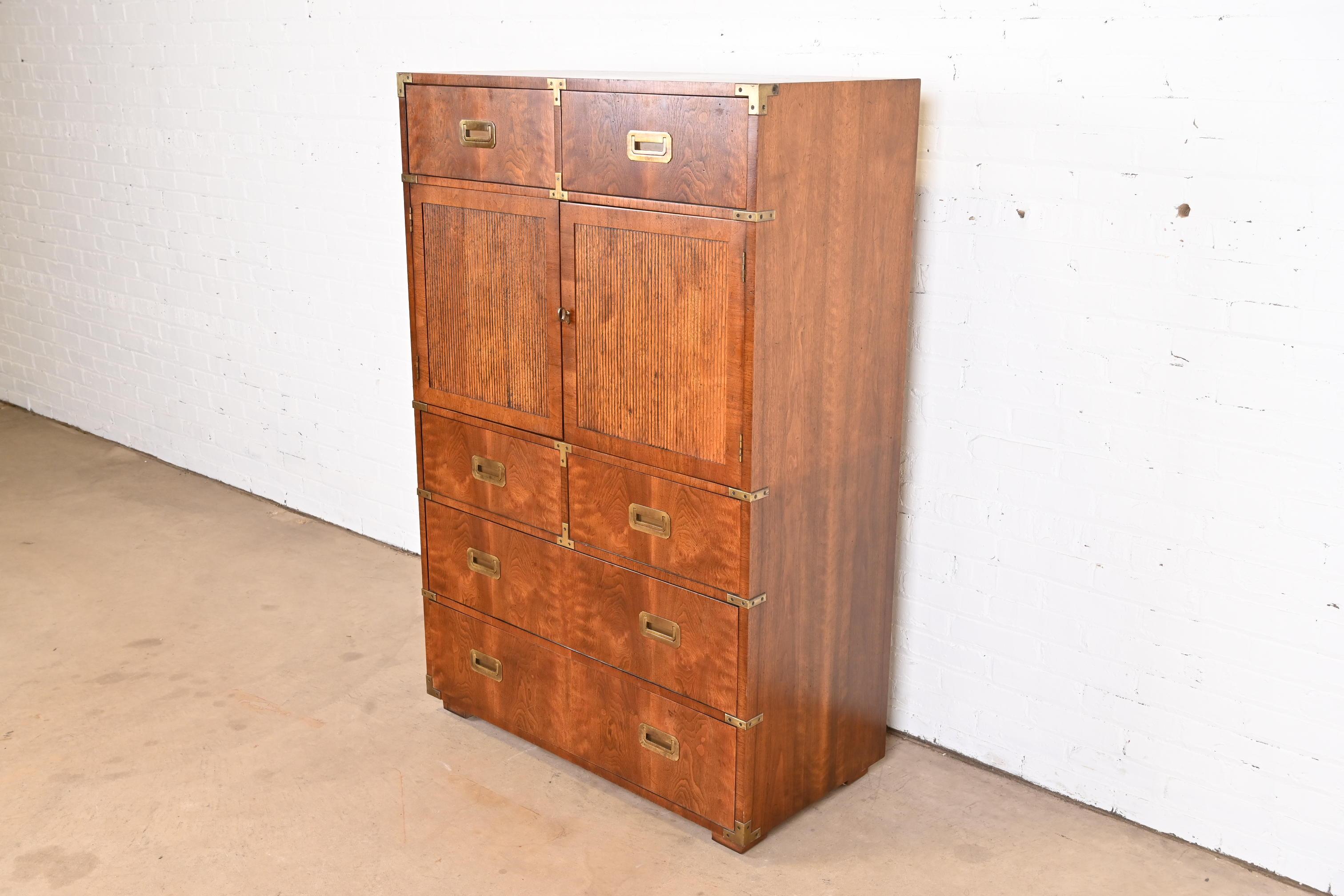 An exceptional mid-century modern Hollywood Regency Campaign style gentleman's chest or highboy dresser

By Henredon

USA, Circa 1970s

Gorgeous figured walnut, with original brass hardware.

Measures: 38.25