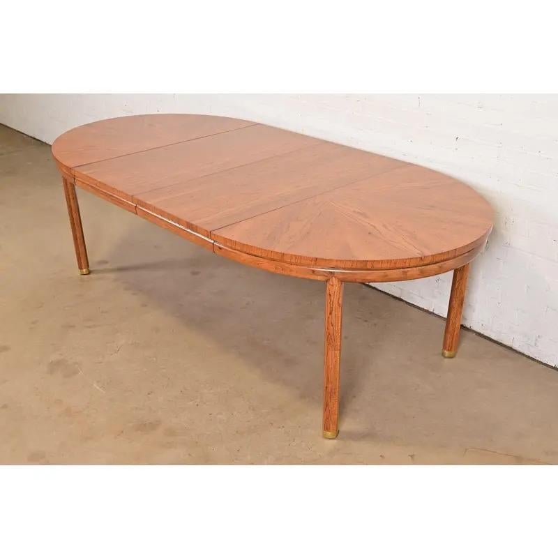 Uno splendido tavolo da pranzo allungabile in stile Mid-Century Modern Hollywood Regency

Da Henredon

USA, circa anni '1970

Bellissimo legno di pecan abbinato al libro, con motivo a stella sulla parte superiore e piedi con tappo in