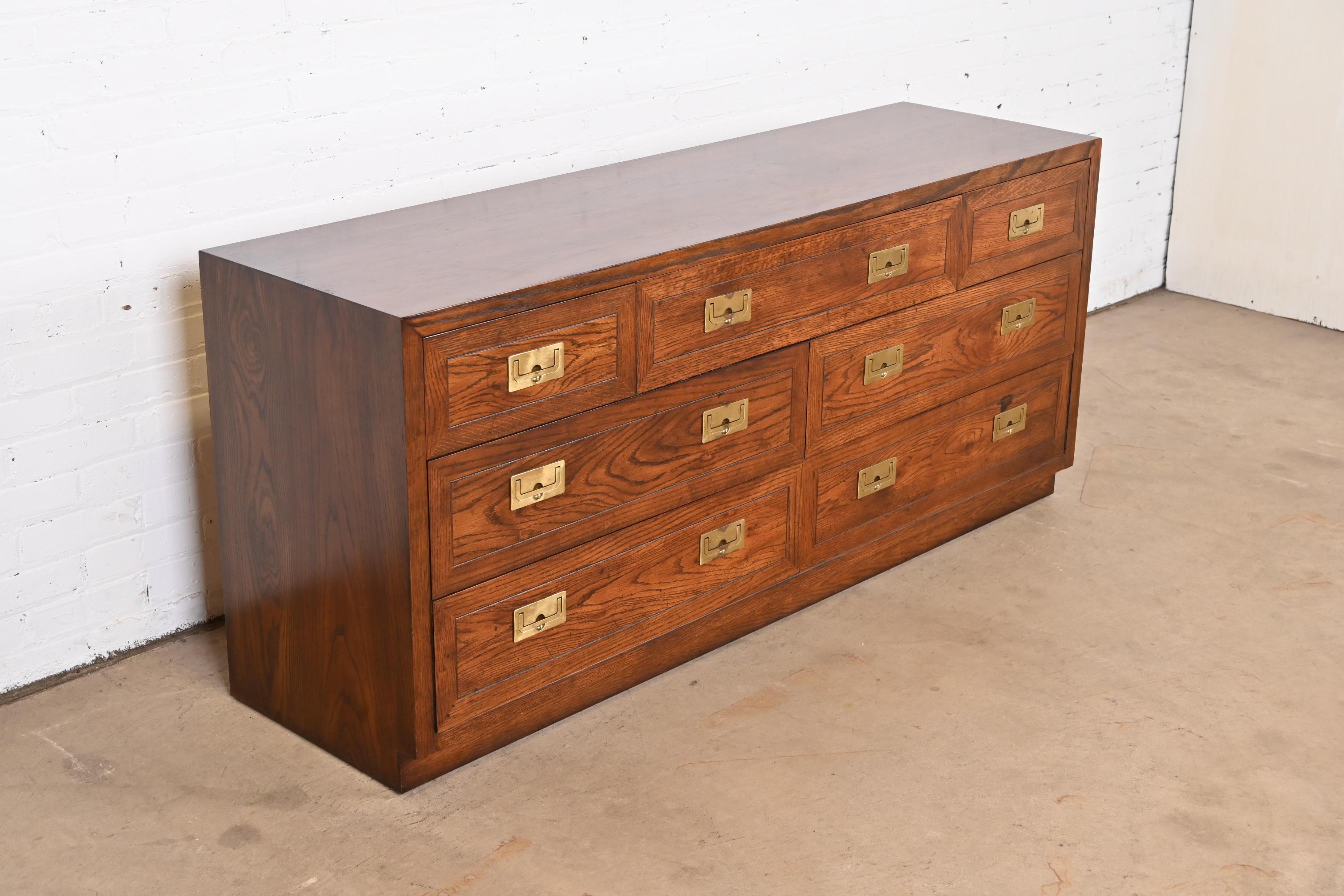 A gorgeous Mid-Century Modern campaign style dresser or credenza.

by Henredon.

USA, Circa 1970s.

Oak, with original brass hardware.

Measures: 64