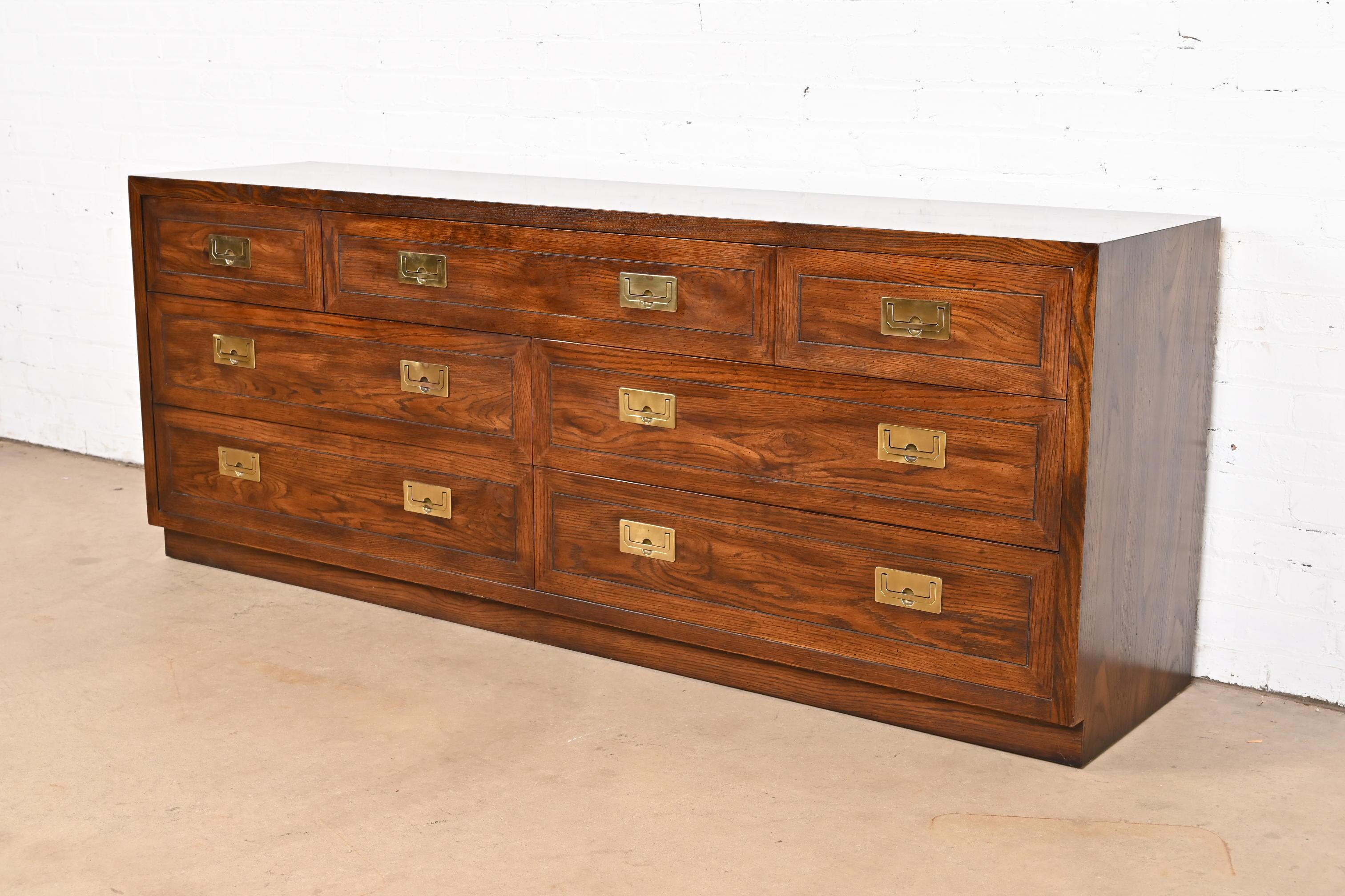 A gorgeous mid-century modern Hollywood Regency Campaign style dresser or credenza

By Henredon

USA, Circa 1970s

Oak, with original brass hardware.

Measures: 72